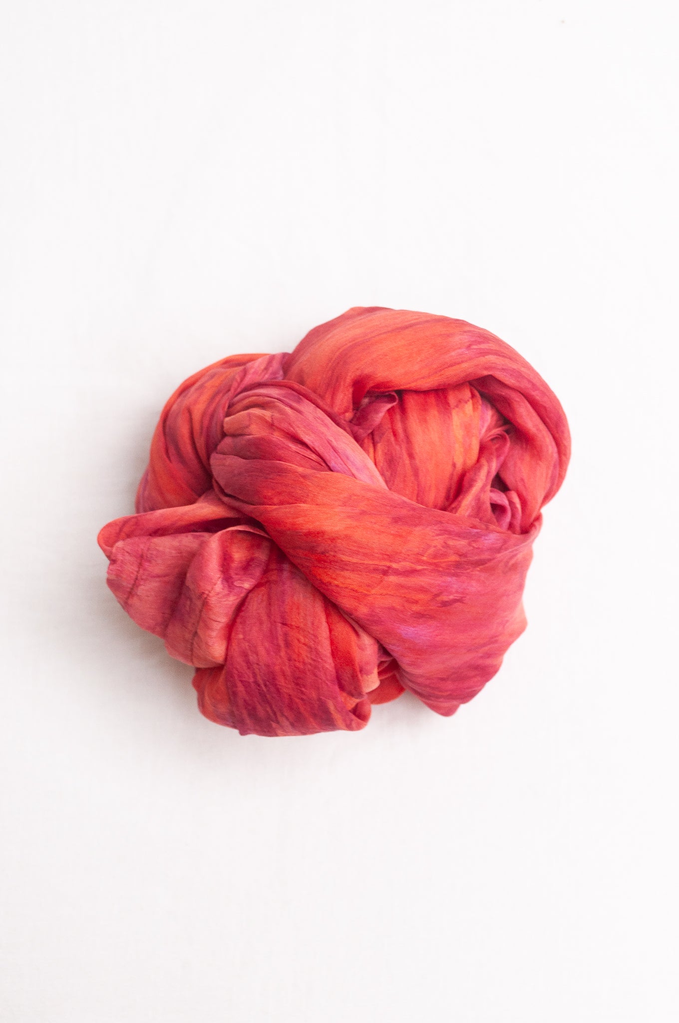 Pure silk shibori dyed scarf in shades of rose pink and red.