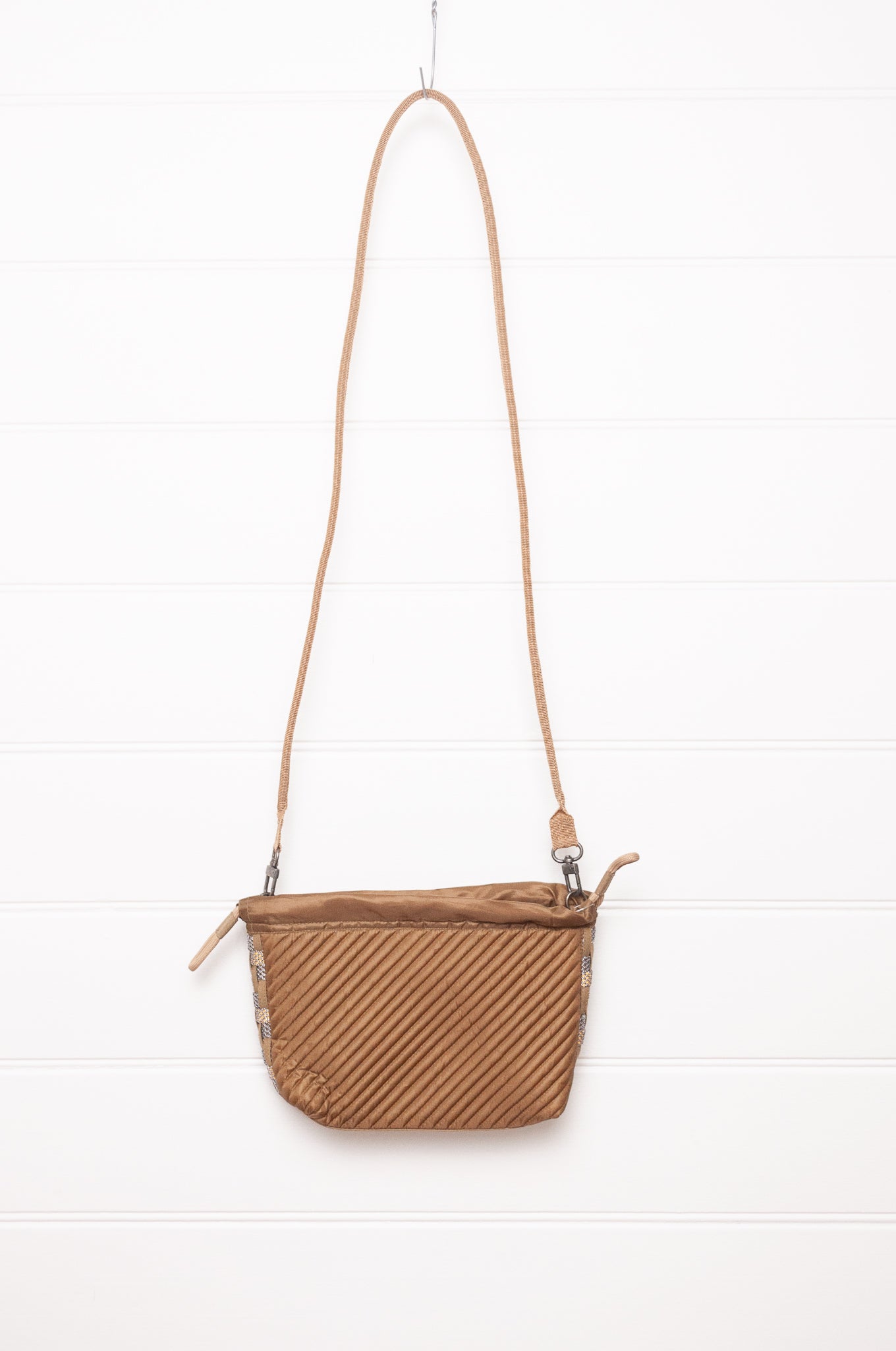 Anna Kaszer quilted drawstring pouch bag in taupe.