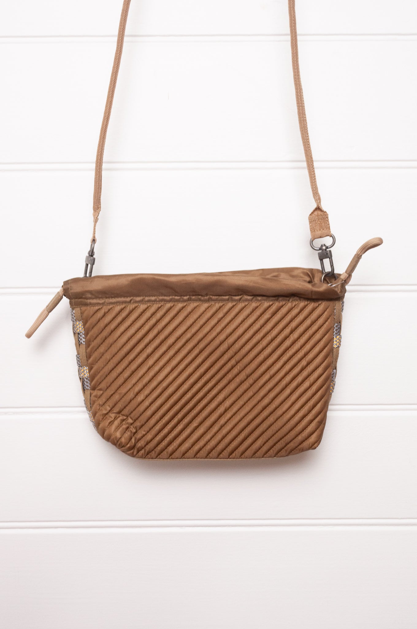 Anna Kaszer quilted drawstring pouch bag in taupe.