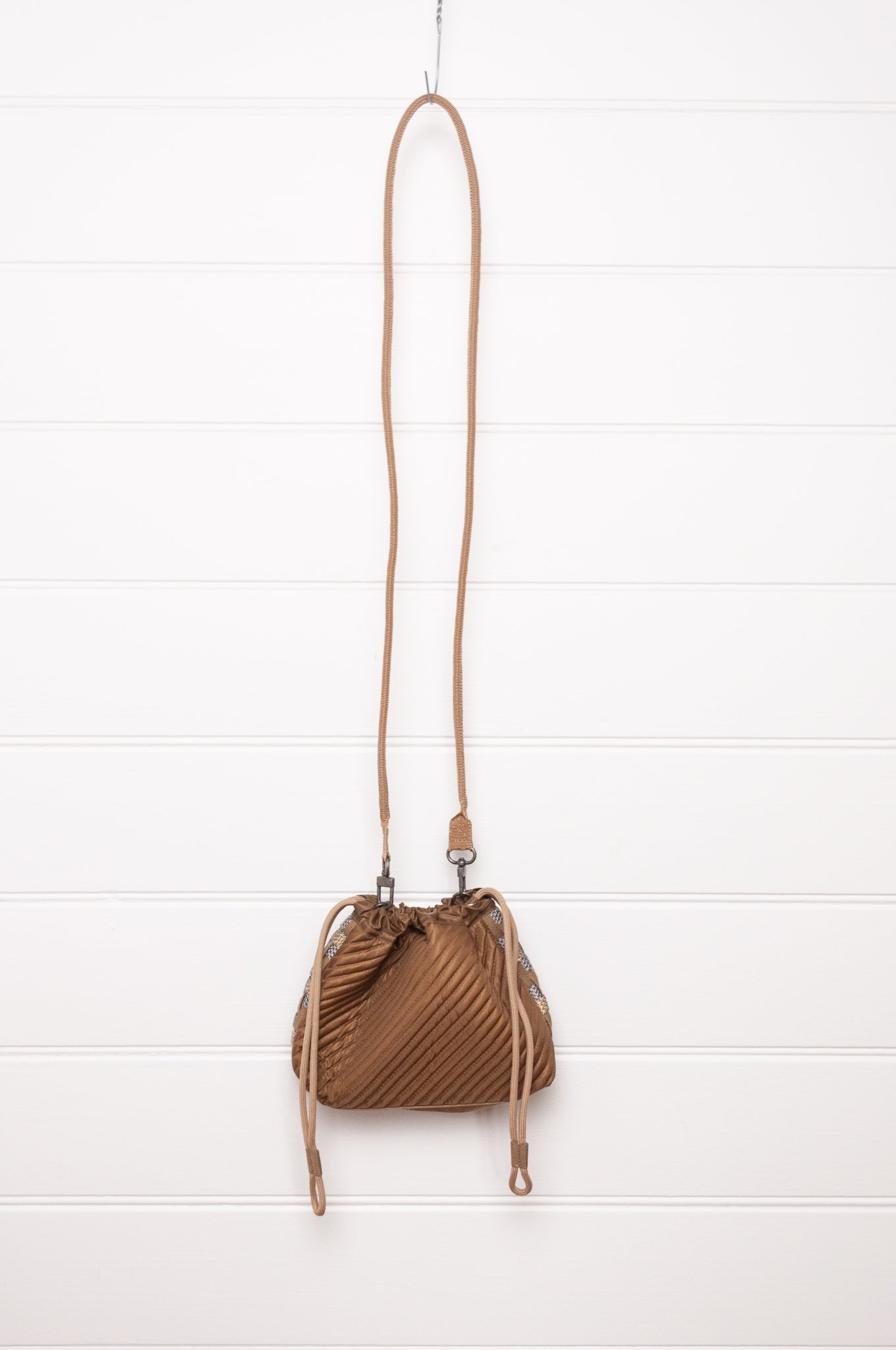 Anna Kaszer quilted drawstring pouch bag in taupe.