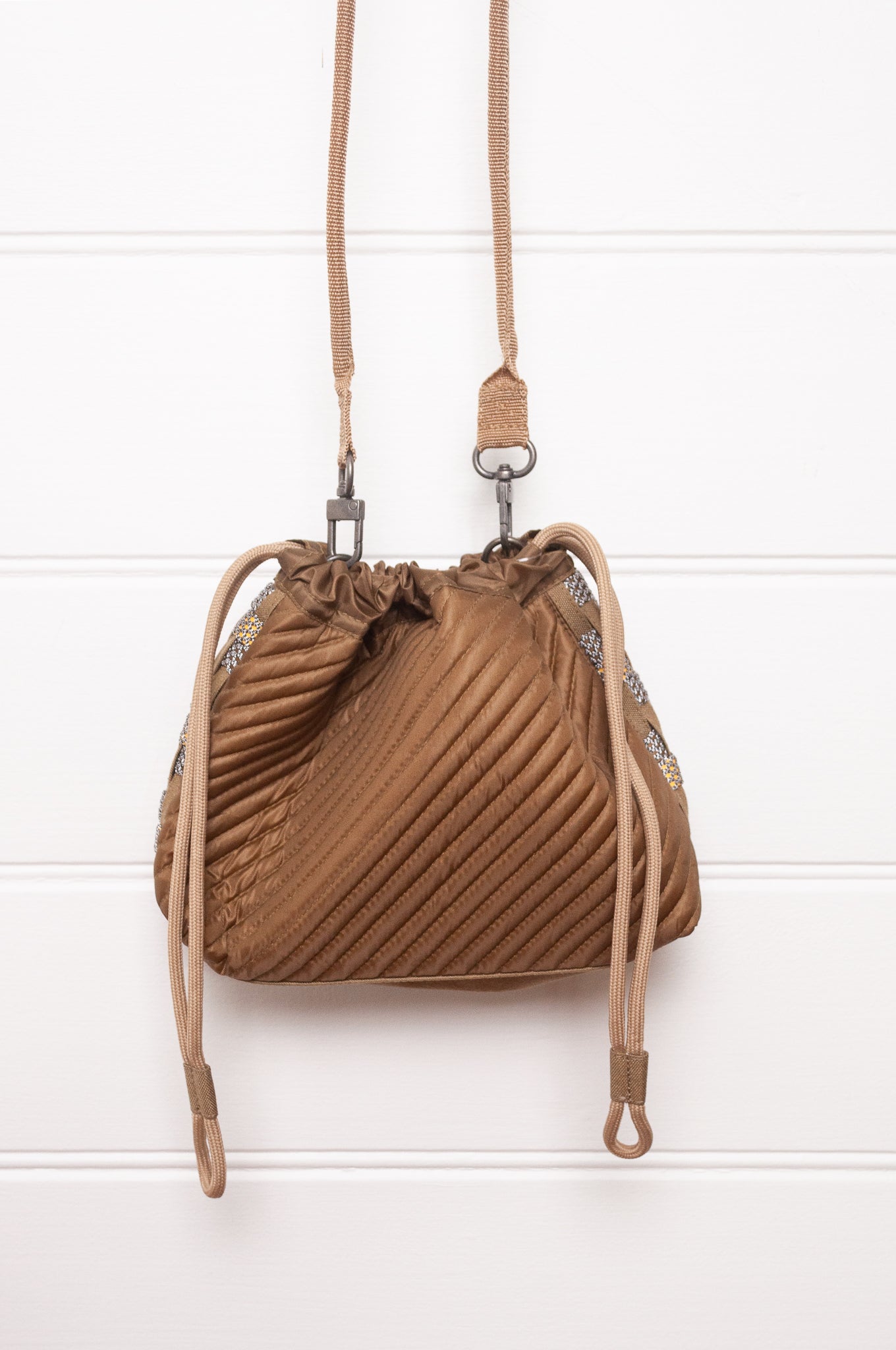 Anna Kaszer quilted drawstring pouch bag in taupe.