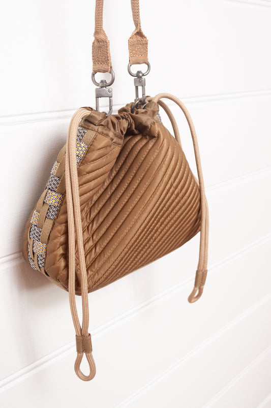 Anna Kaszer quilted drawstring pouch bag in taupe.