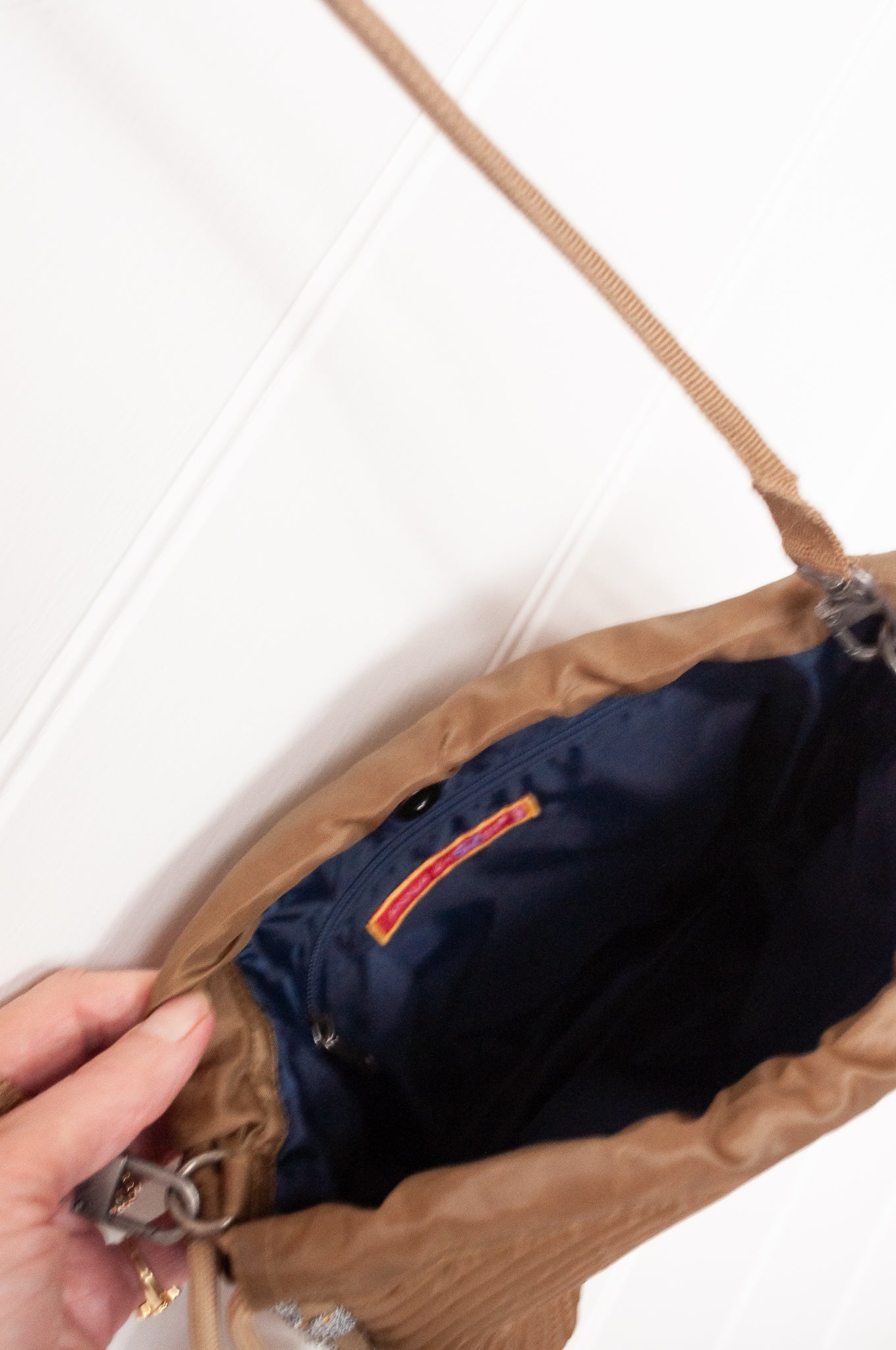 Anna Kaszer quilted drawstring pouch bag in taupe.
