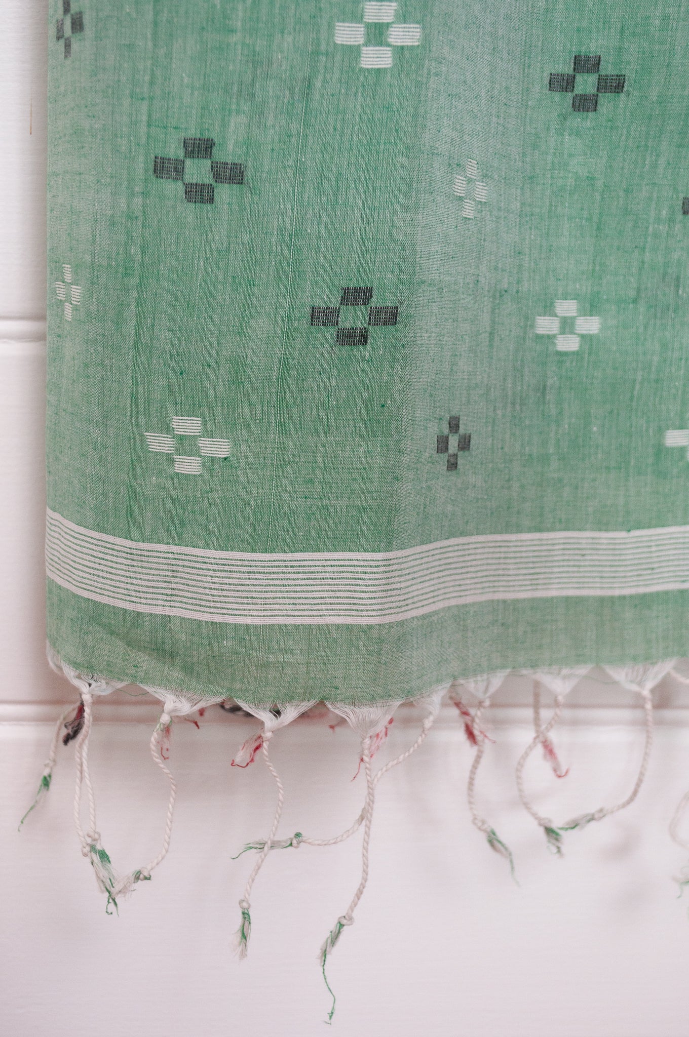 Handwoven light cotton jamdani scarf in light emerald green, coral and white.