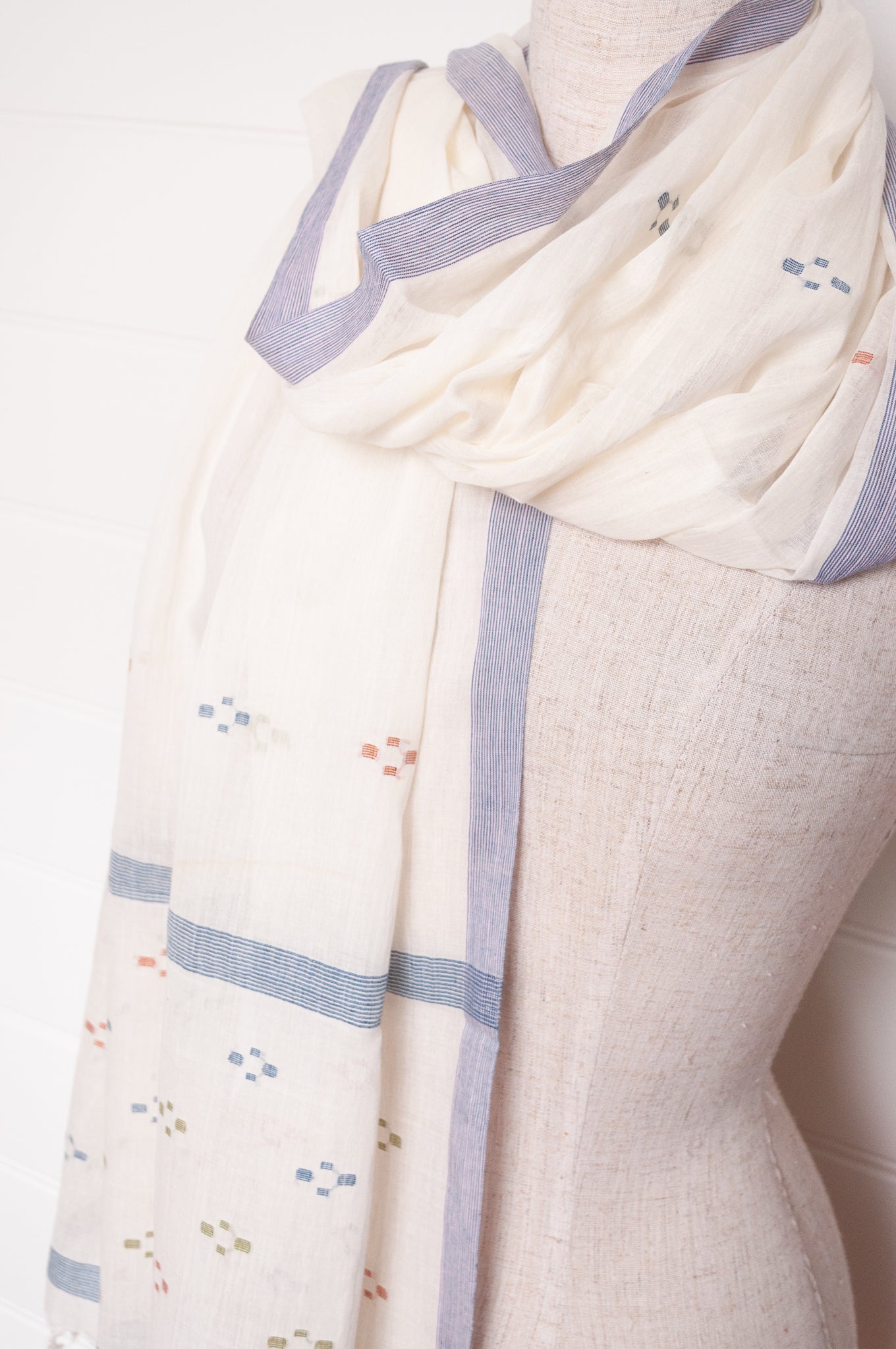 Handwoven light cotton jamdani scarf in ecru with multi-coloured motifs.