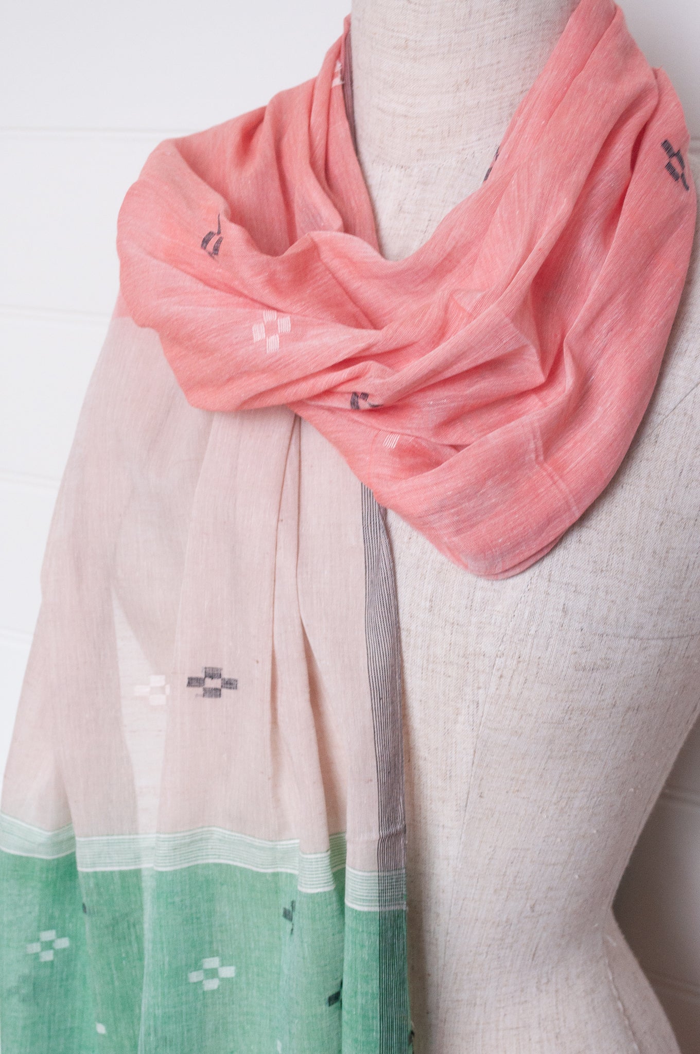 Handwoven light cotton jamdani scarf in light emerald green, coral and white.