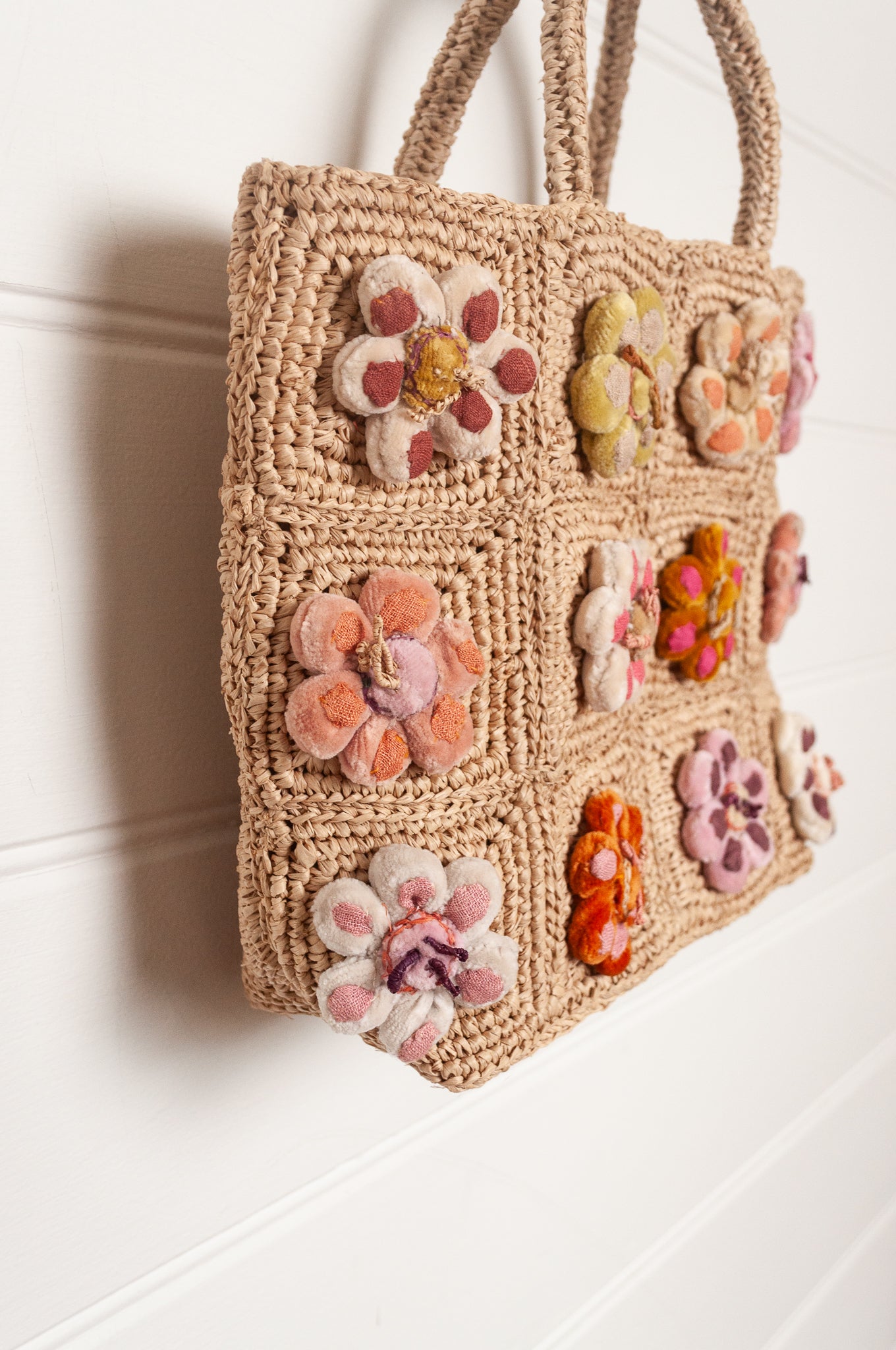 Sophie Digard crochet raffia bag in natural with pastel embroidered velvet flowers.