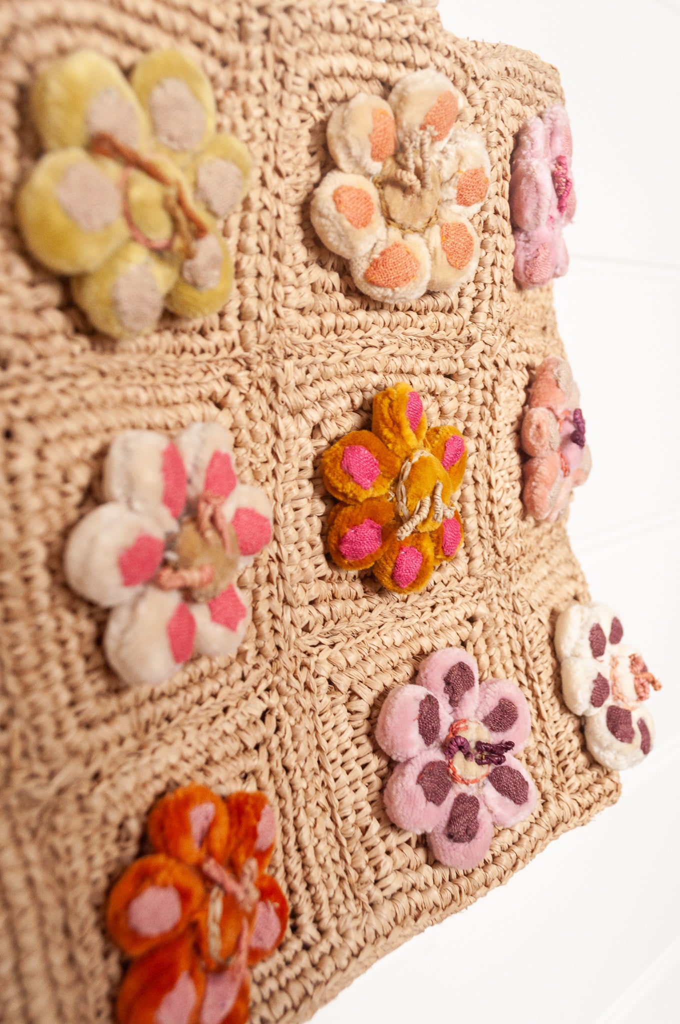 Sophie Digard crochet raffia bag in natural with pastel embroidered velvet flowers.