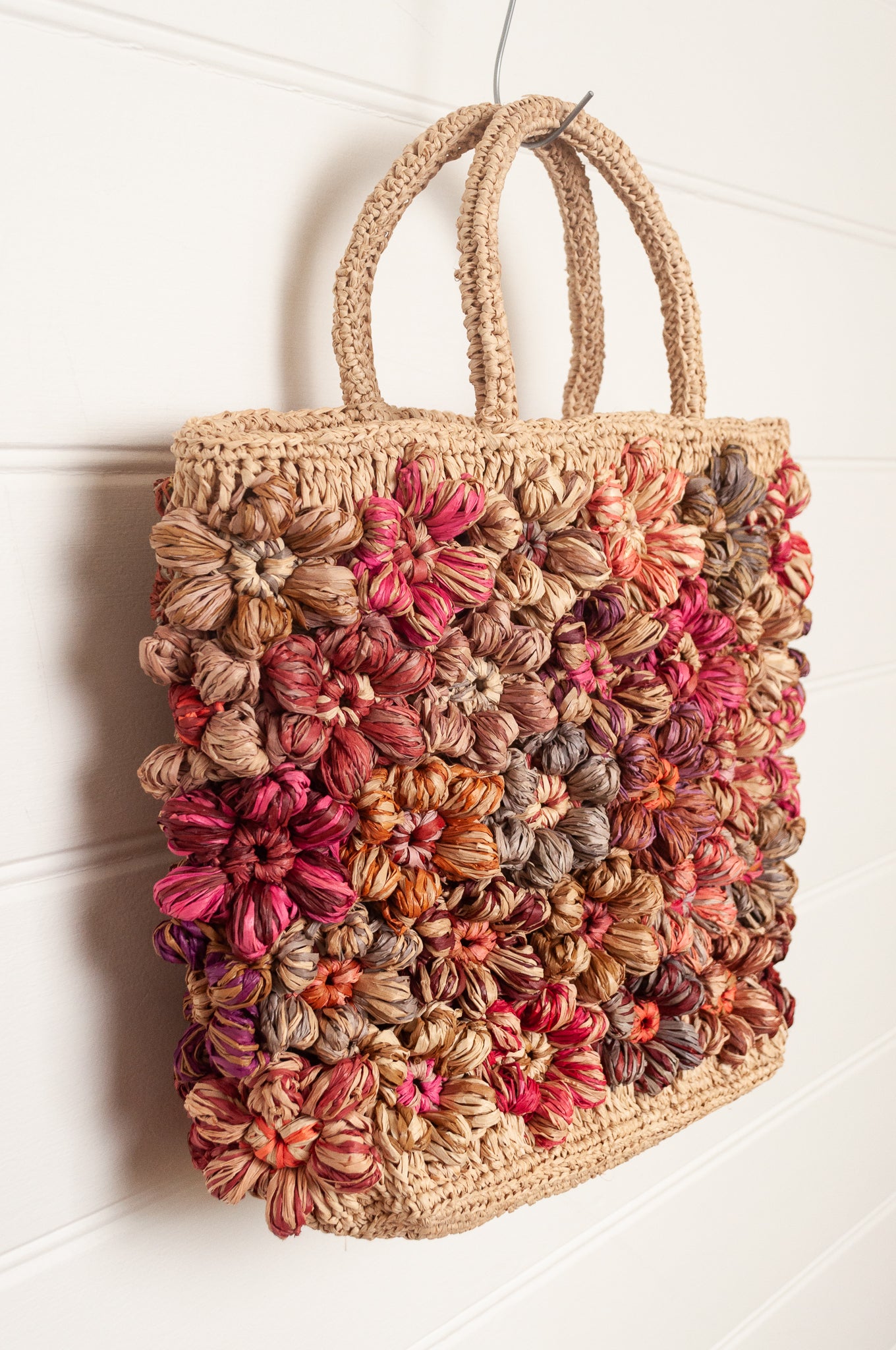 Sophie Digard natural raffia crocheted bag with all over flowers in reds and pinks.