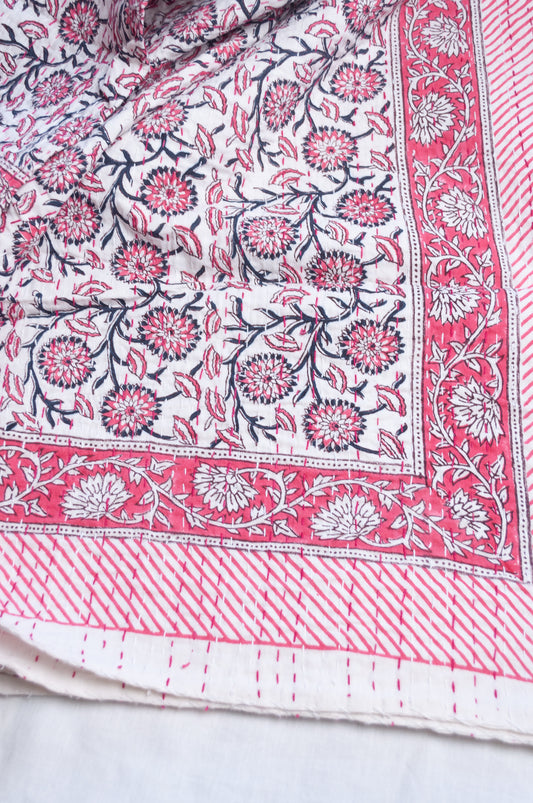Cotton kantha quilt in raspberry pink floral on white.