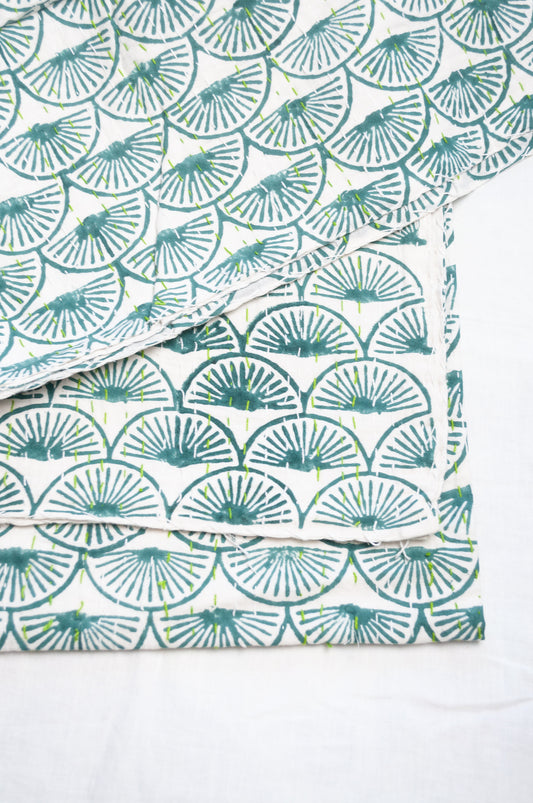 Cotton kantha quilt in teal green fans on white.