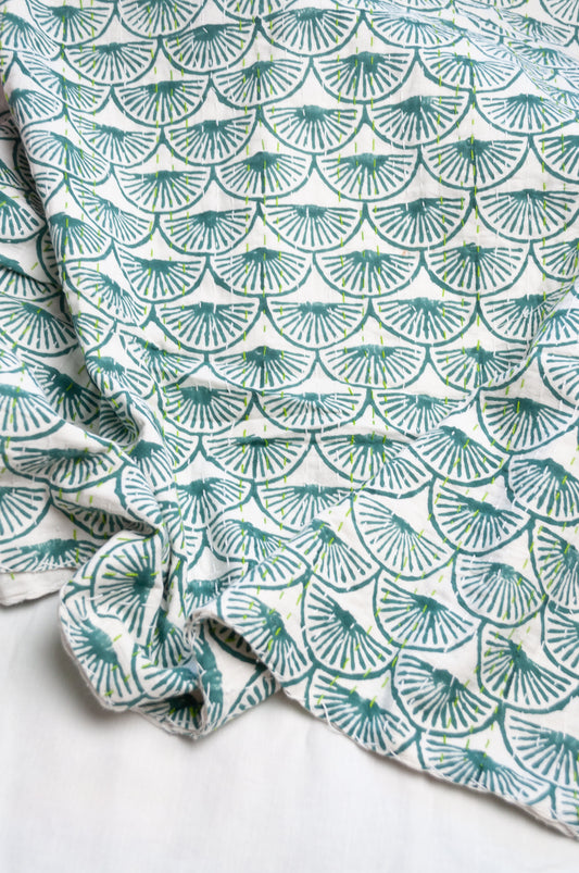 Cotton kantha quilt in teal green fans on white.