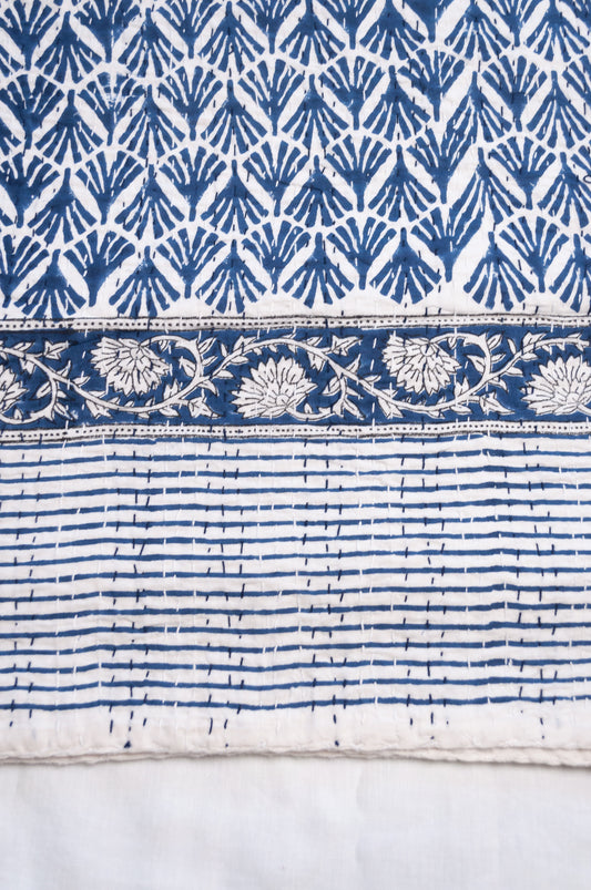 Indigo fan and floral on white cotton kantha quilt.