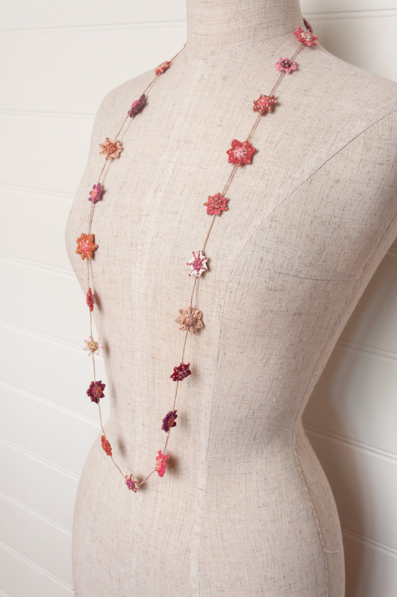 Sophie Digard star flower embroidered linen necklace in pinks and reds.