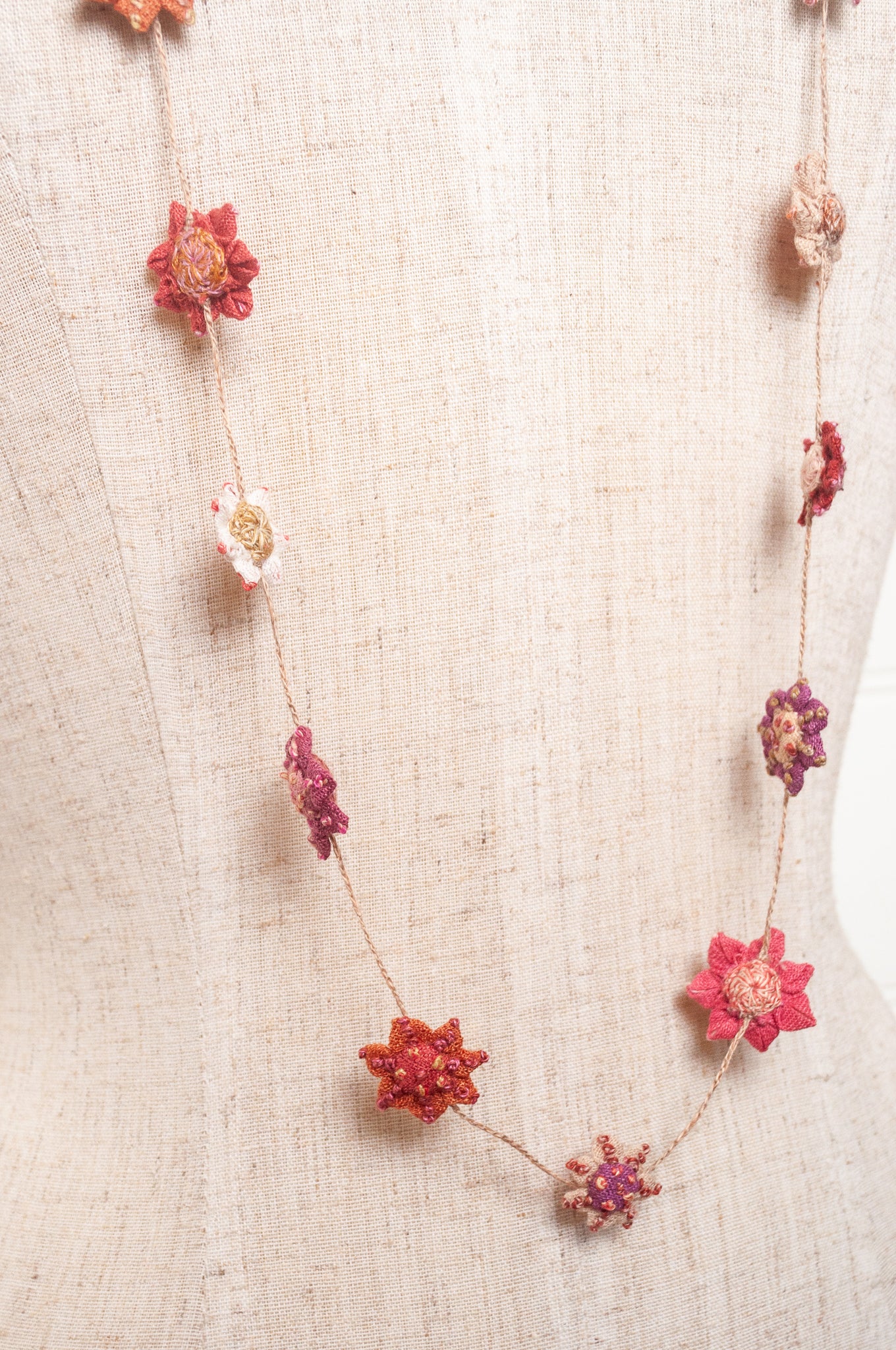Sophie Digard star flower embroidered linen necklace in pinks and reds.