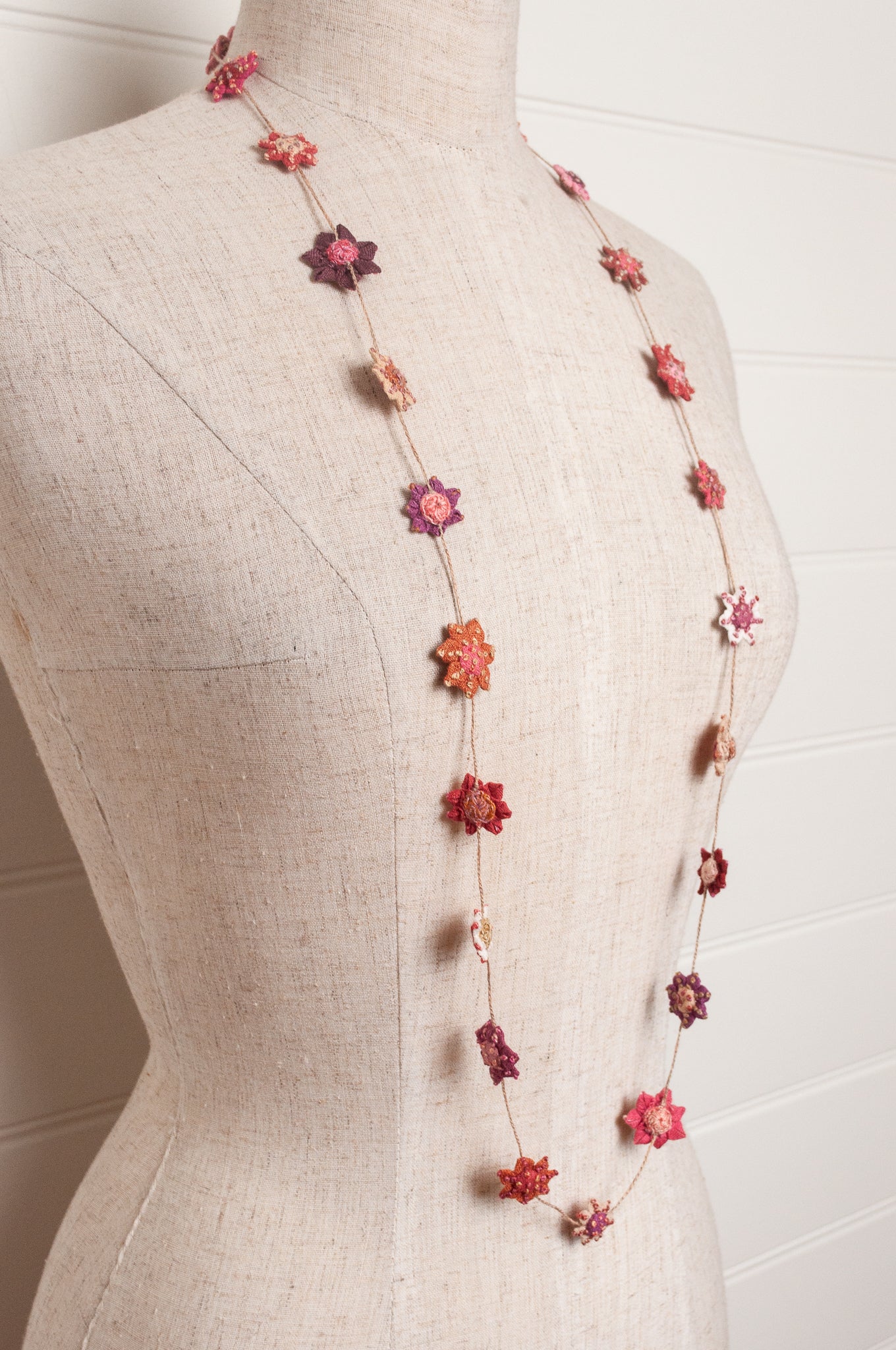 Sophie Digard star flower embroidered linen necklace in pinks and reds.