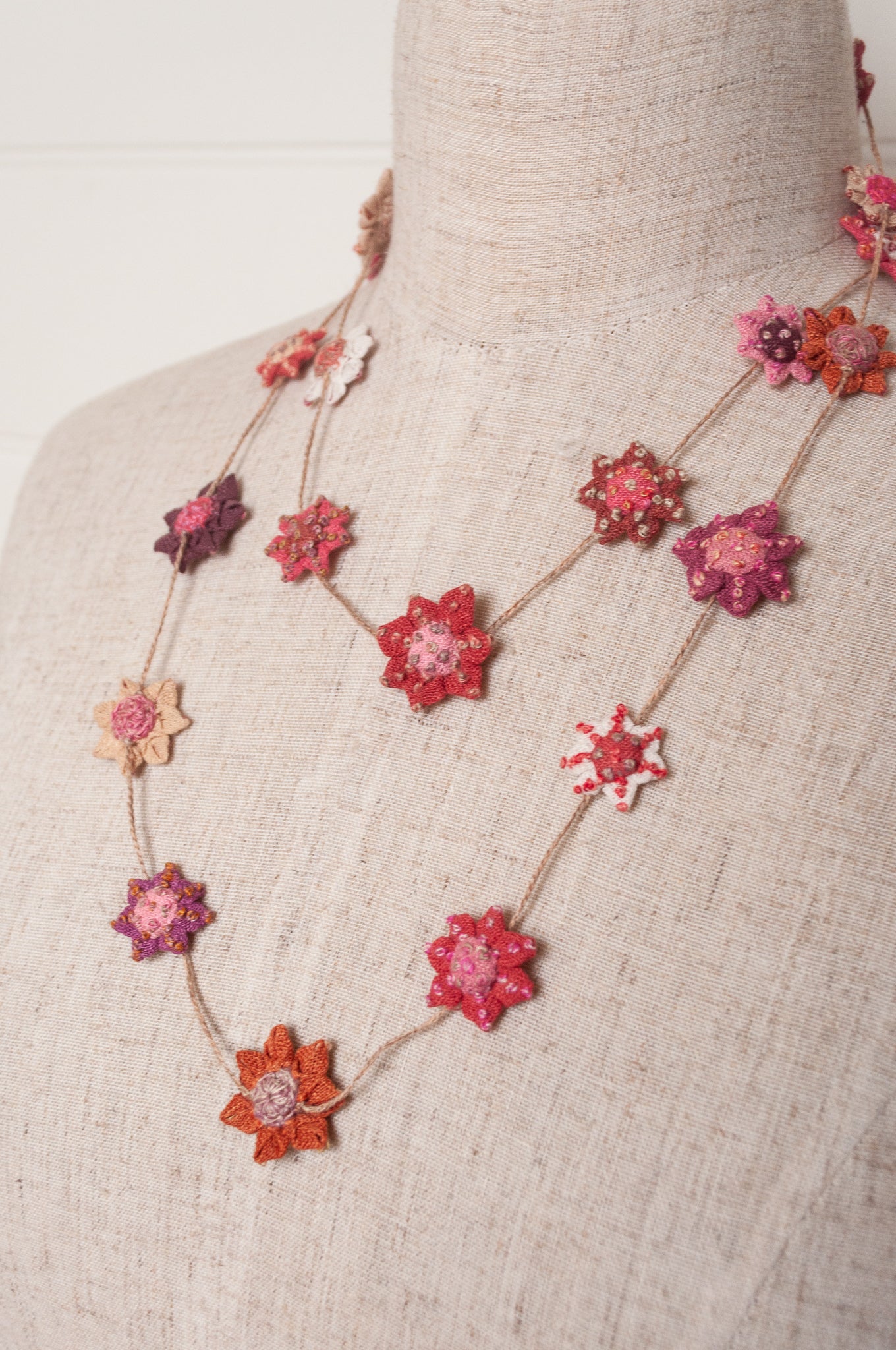 Sophie Digard star flower embroidered linen necklace in pinks and reds.