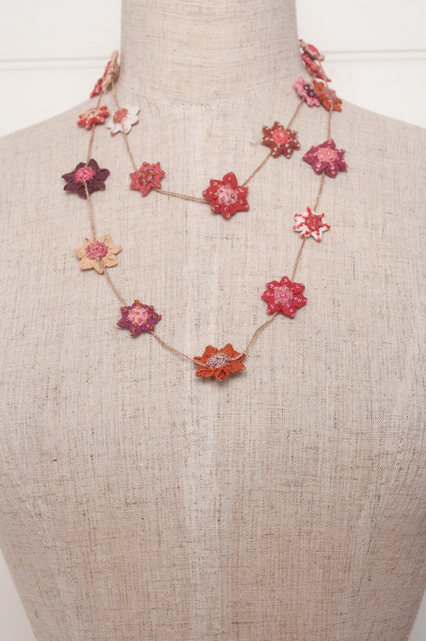 Sophie Digard star flower embroidered linen necklace in pinks and reds.