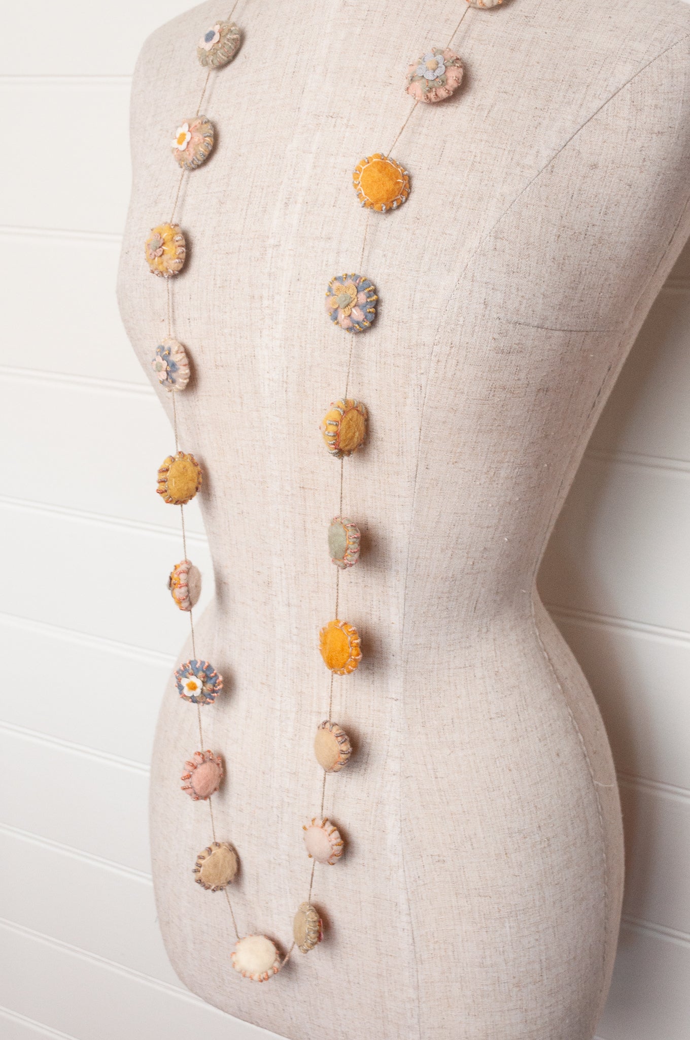 Sophie Digard necklace of linen medallions with flower embroidery.