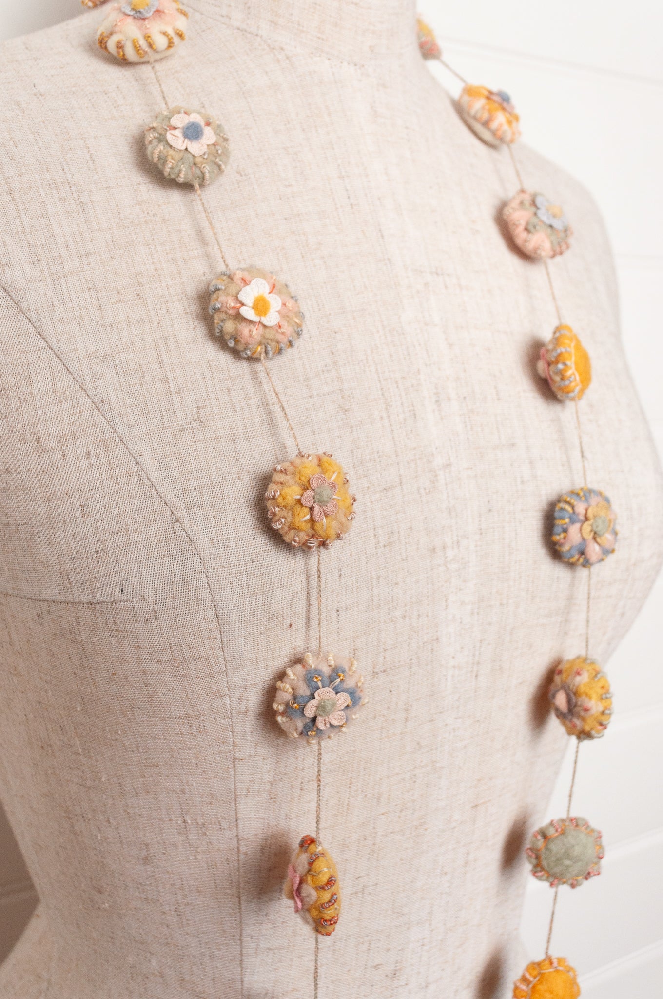 Sophie Digard necklace of linen medallions with flower embroidery.