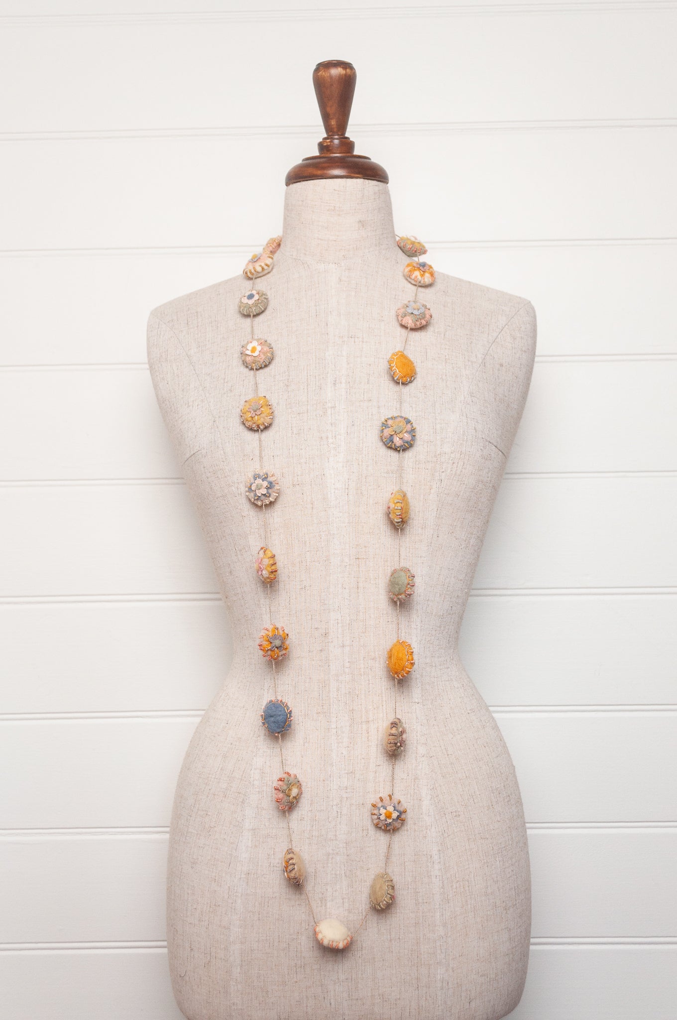 Sophie Digard necklace of linen medallions with flower embroidery.