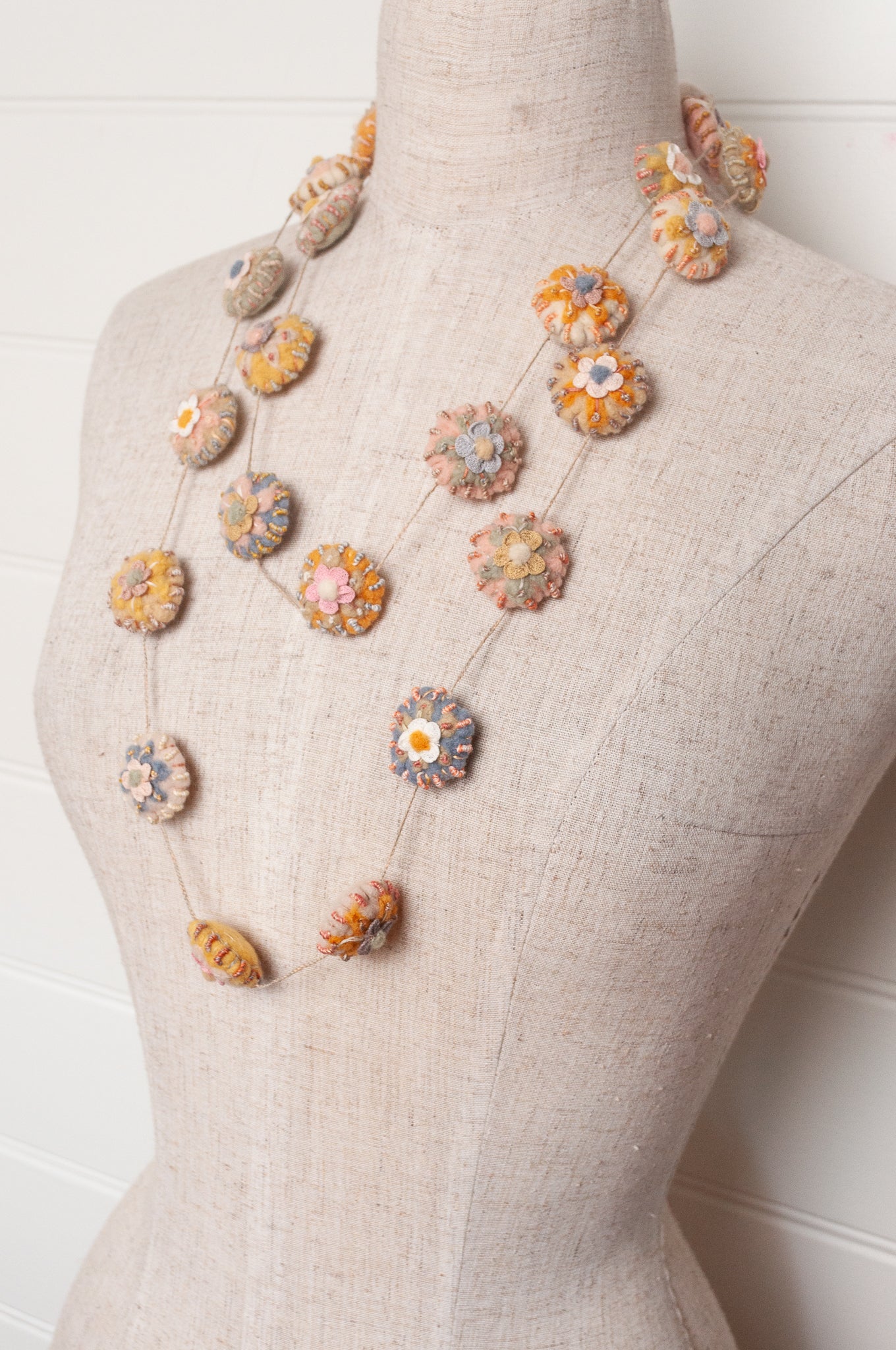 Sophie Digard necklace of linen medallions with flower embroidery.