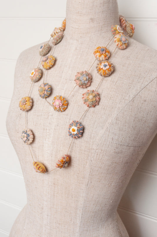 Sophie Digard necklace of linen medallions with flower embroidery.