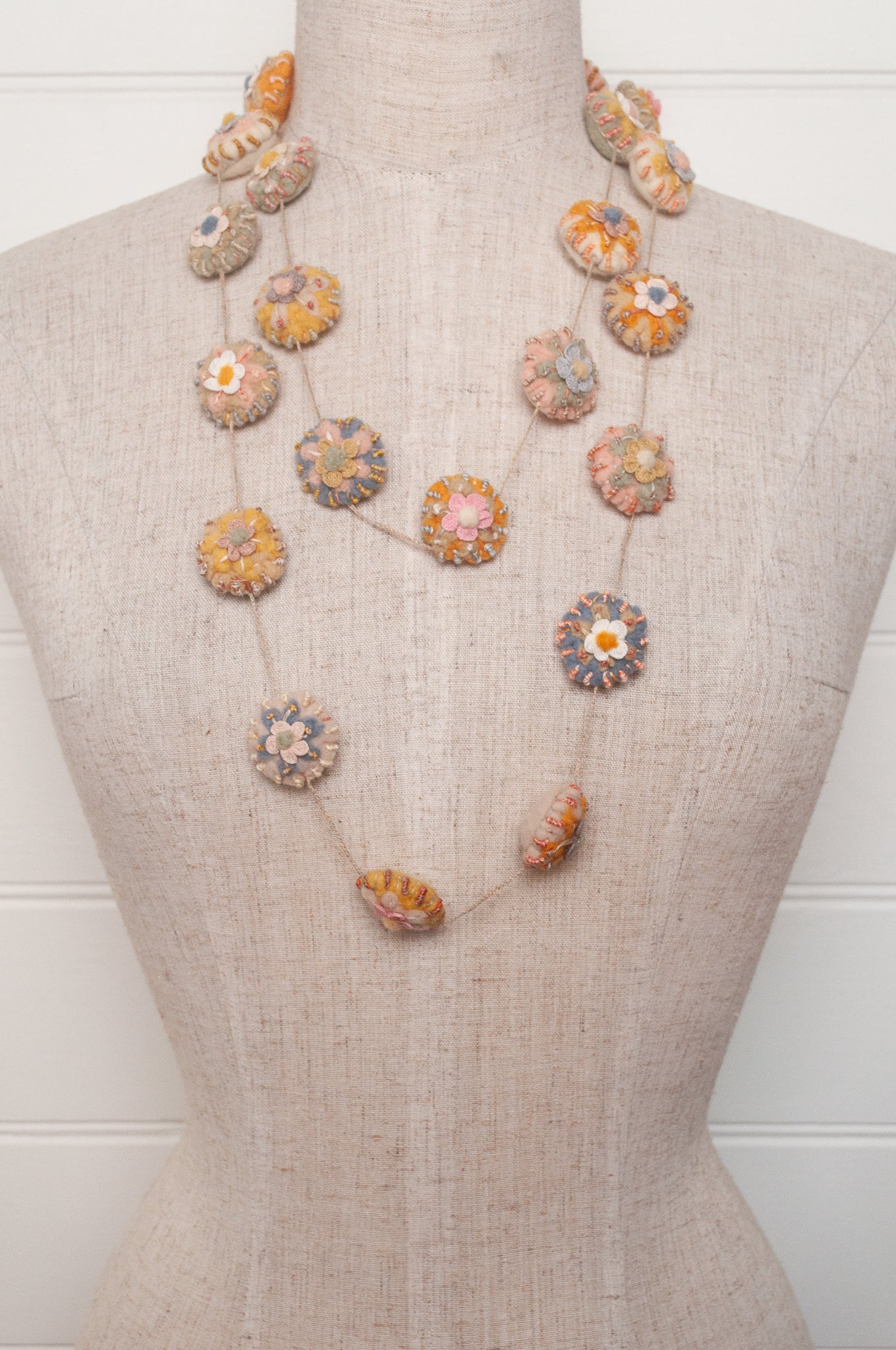 Sophie Digard necklace of linen medallions with flower embroidery.
