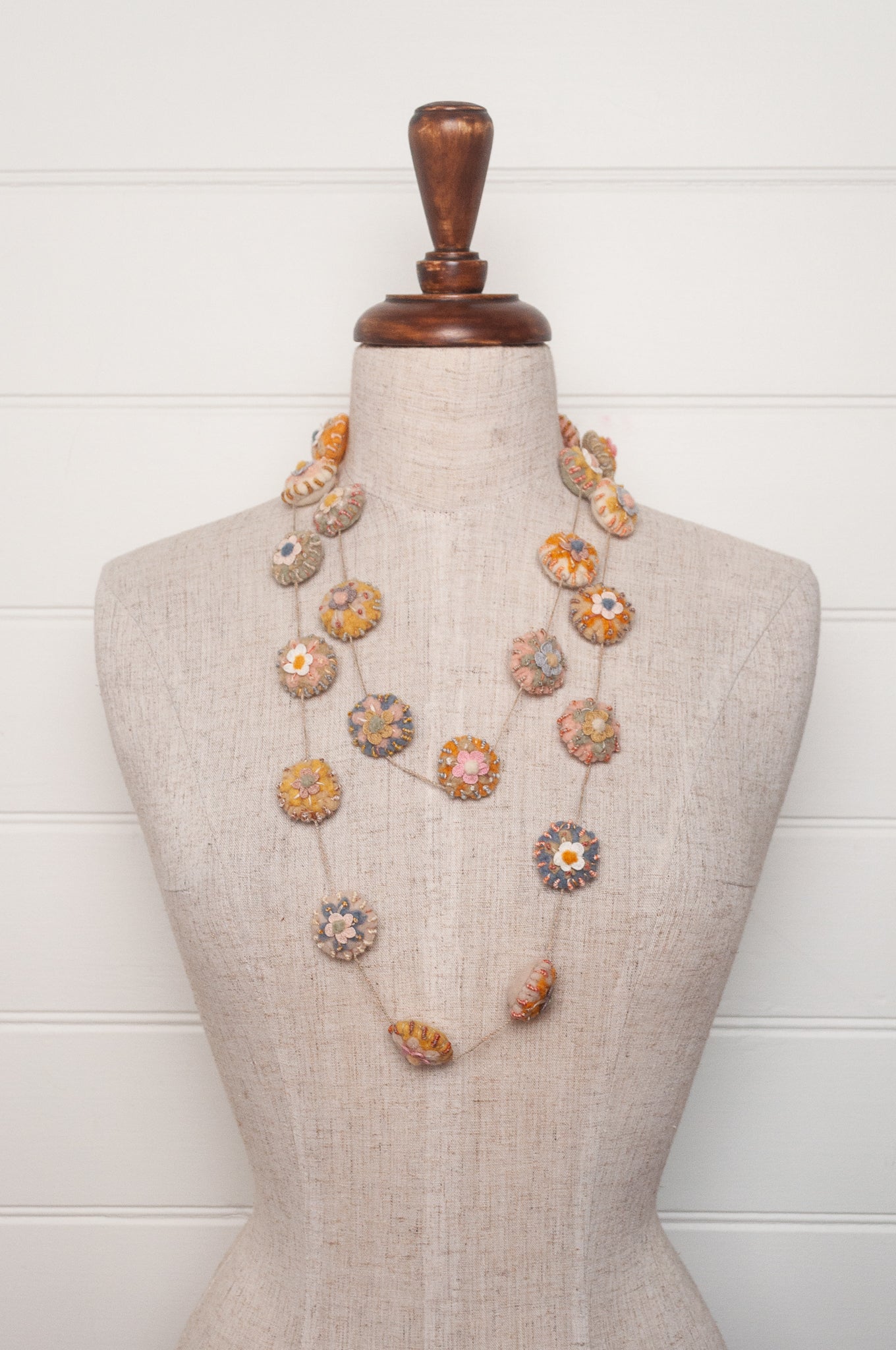 Sophie Digard necklace of linen medallions with flower embroidery.