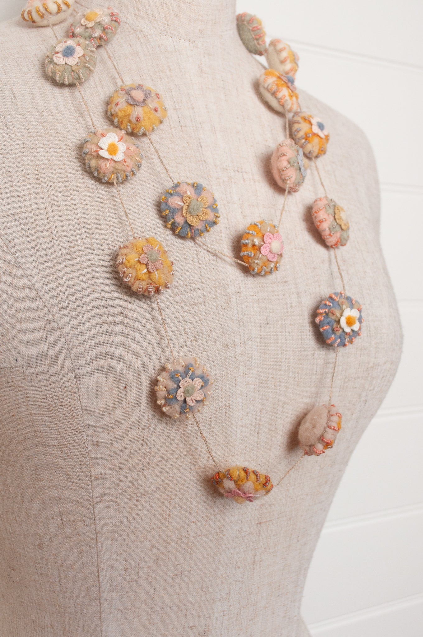 Sophie Digard necklace of linen medallions with flower embroidery.