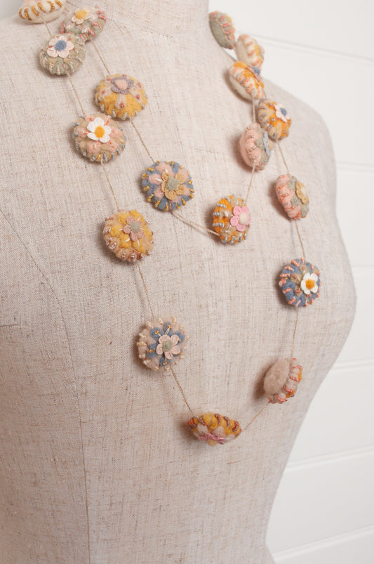 Sophie Digard necklace of linen medallions with flower embroidery.