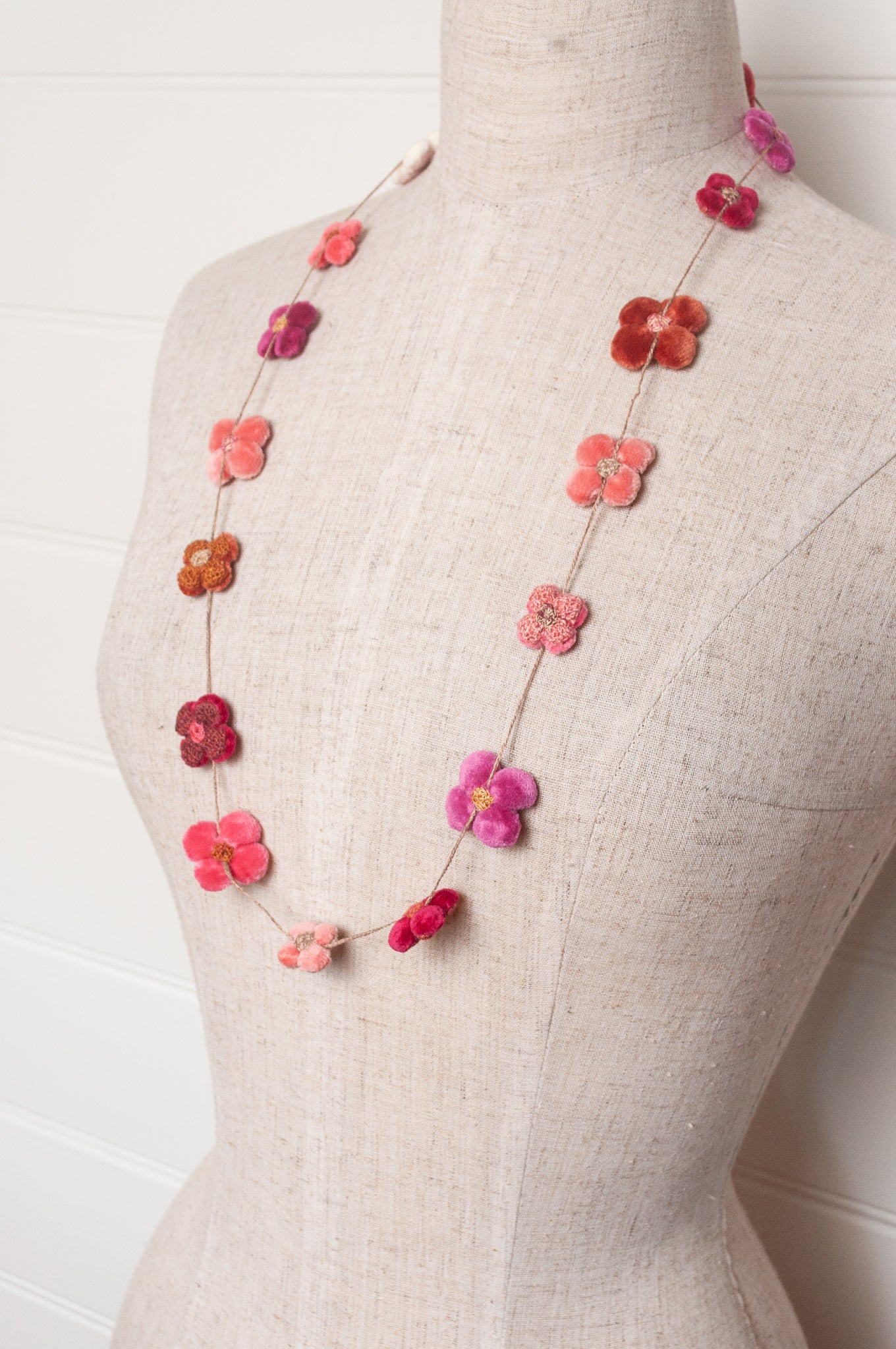 Sophie Digard velvet four petal flower necklace in pinks and reds.