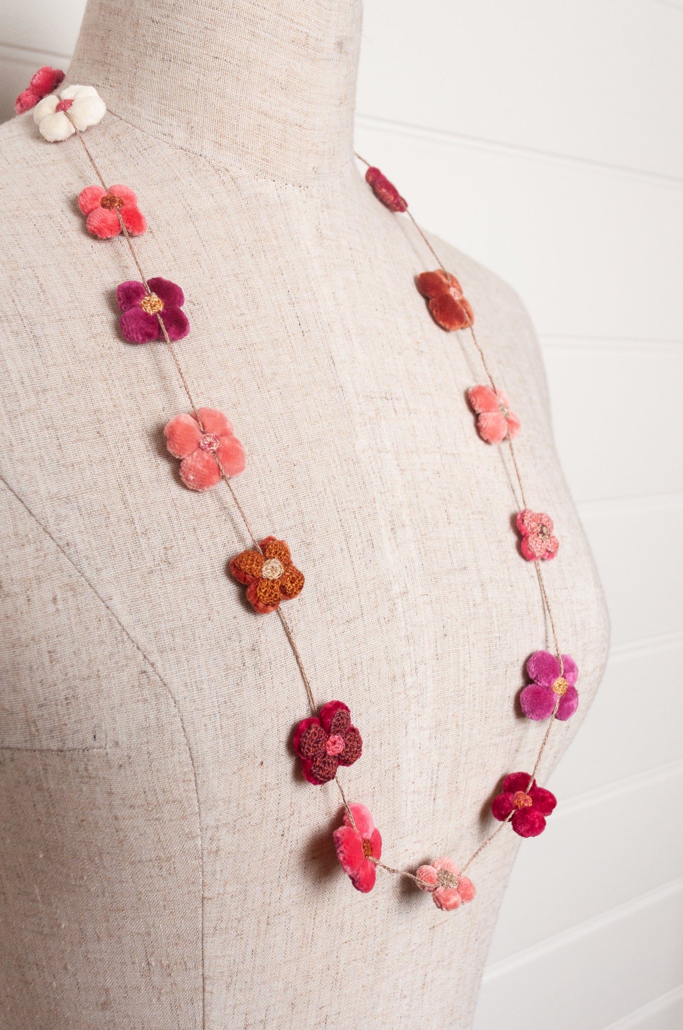 Sophie Digard velvet four petal flower necklace in pinks and reds.