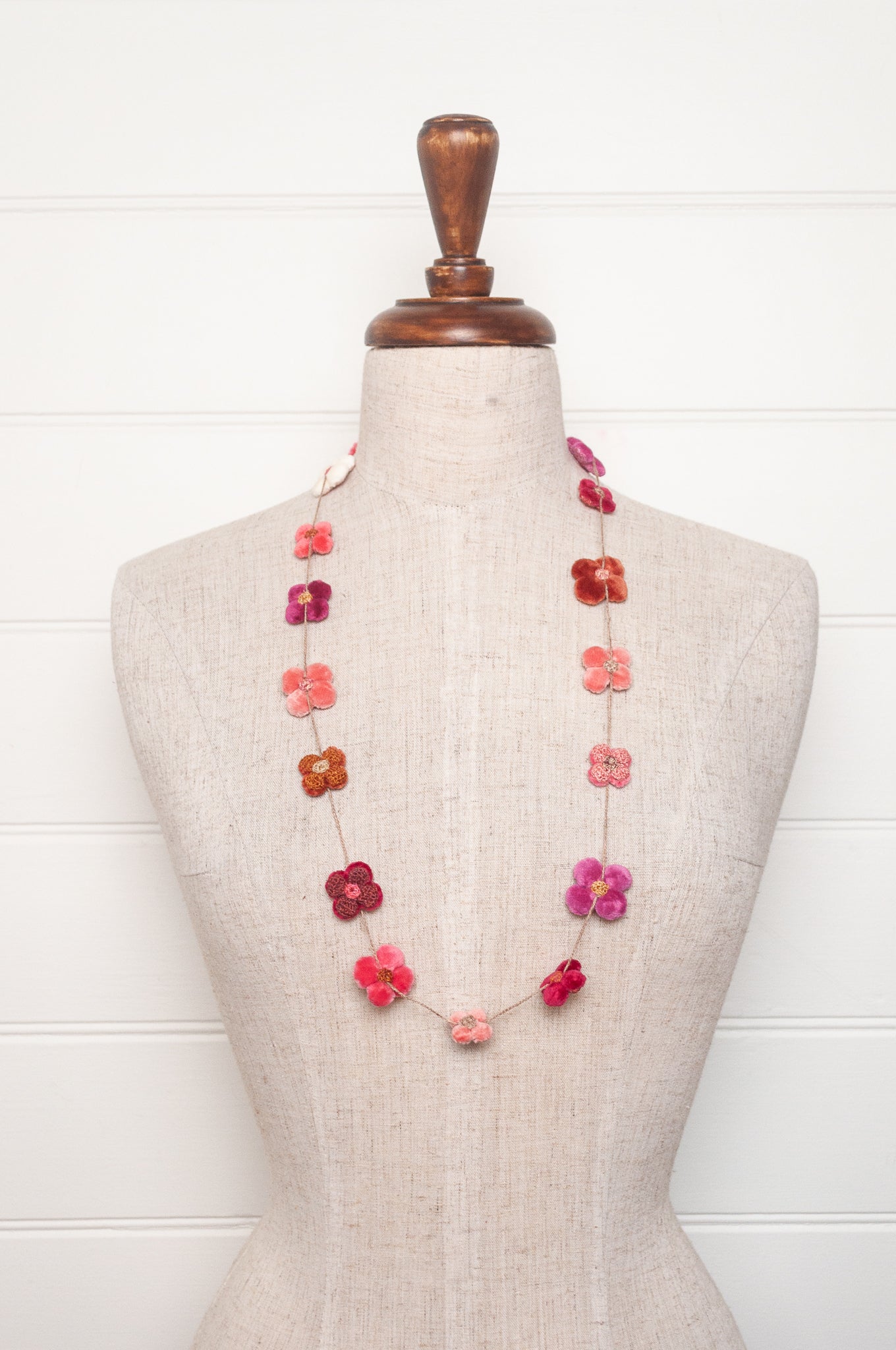 Sophie Digard velvet four petal flower necklace in pinks and reds.