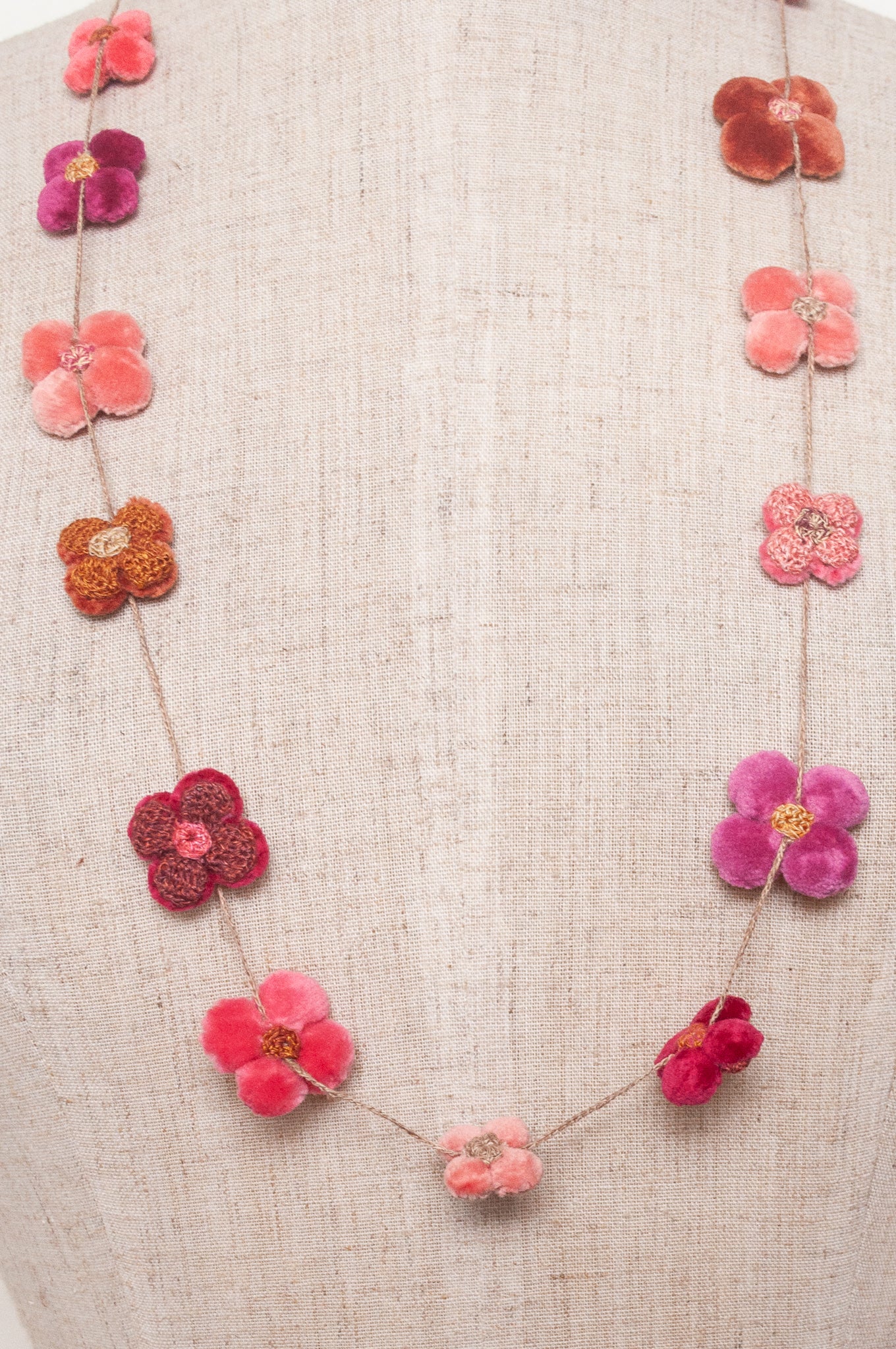 Sophie Digard velvet four petal flower necklace in pinks and reds.