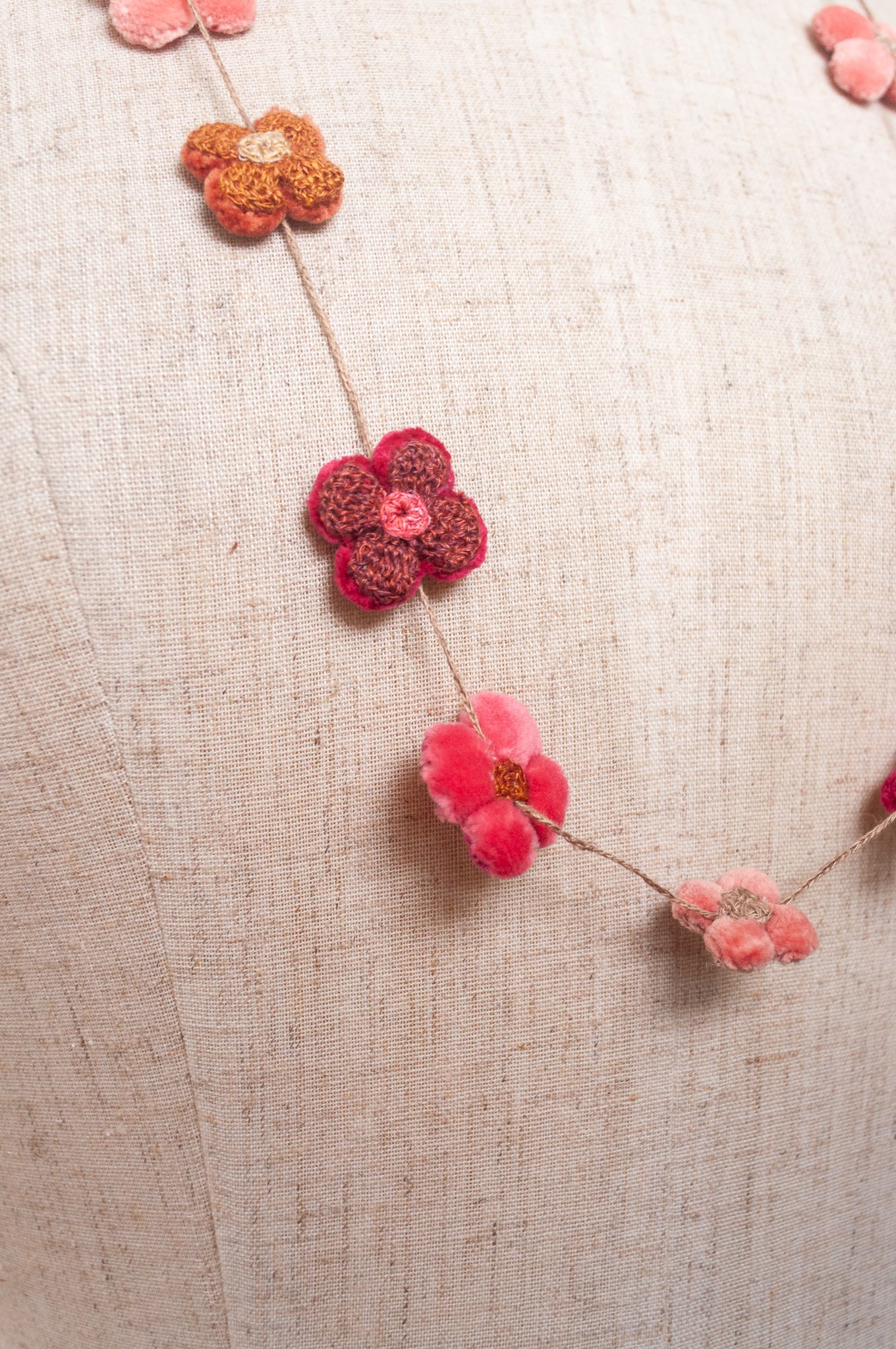 Sophie Digard velvet four petal flower necklace in pinks and reds.