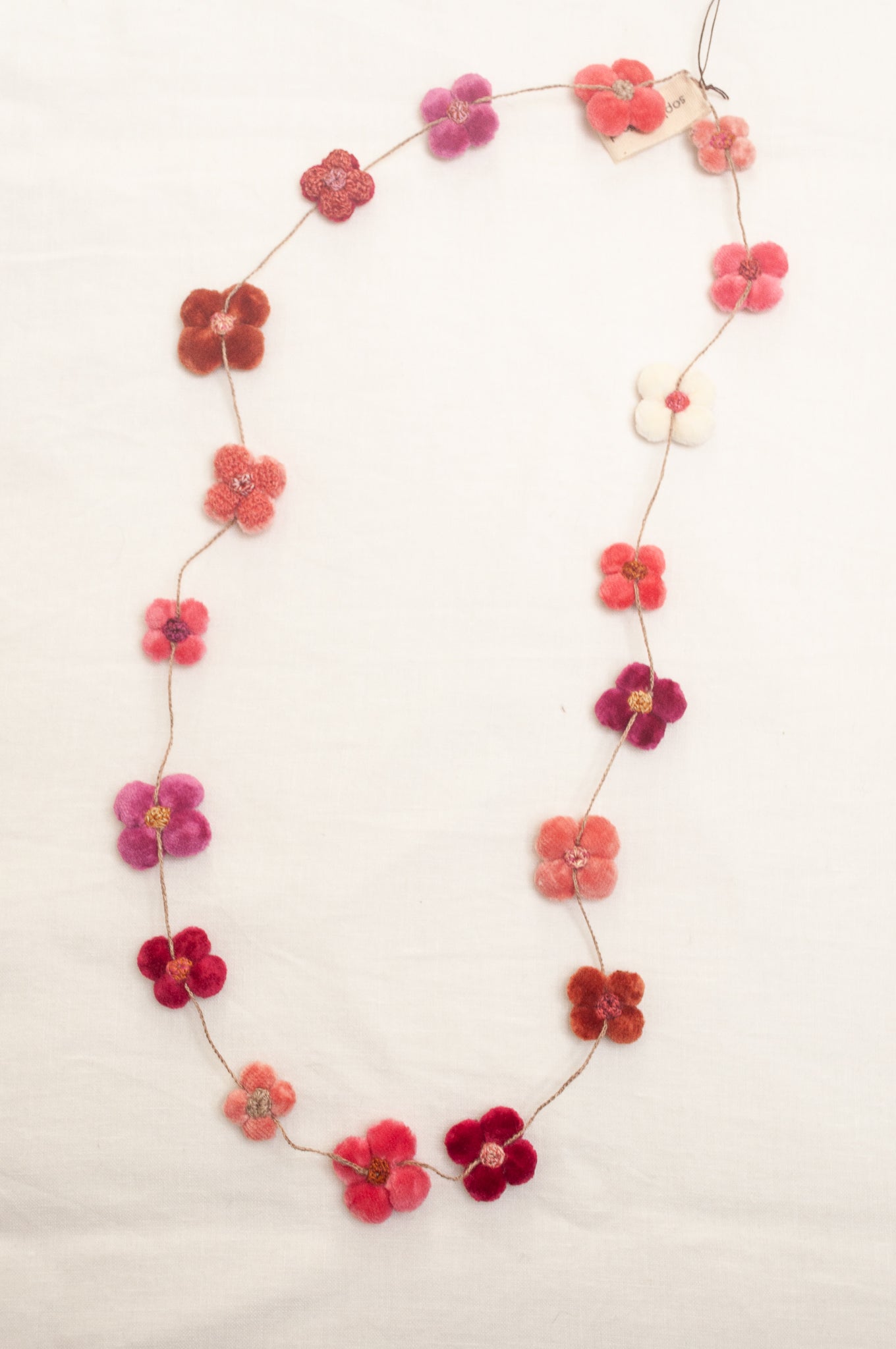 Sophie Digard velvet four petal flower necklace in pinks and reds.