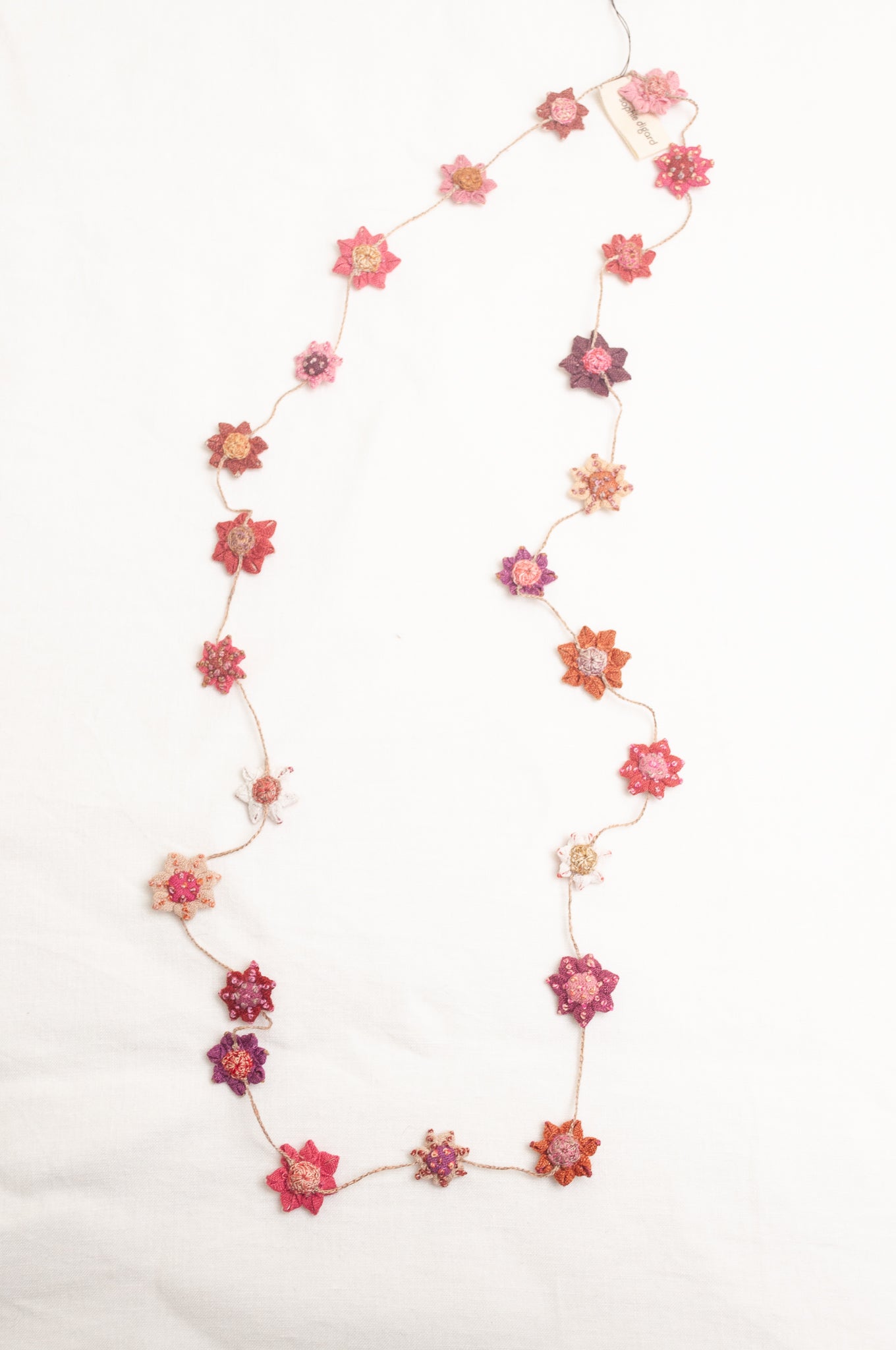 Sophie Digard star flower embroidered linen necklace in pinks and reds.