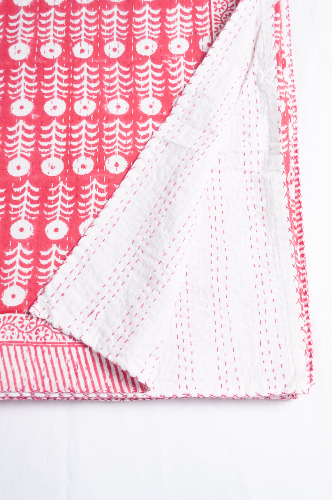 Pink and white floral blockprint cotton kantha quilt.