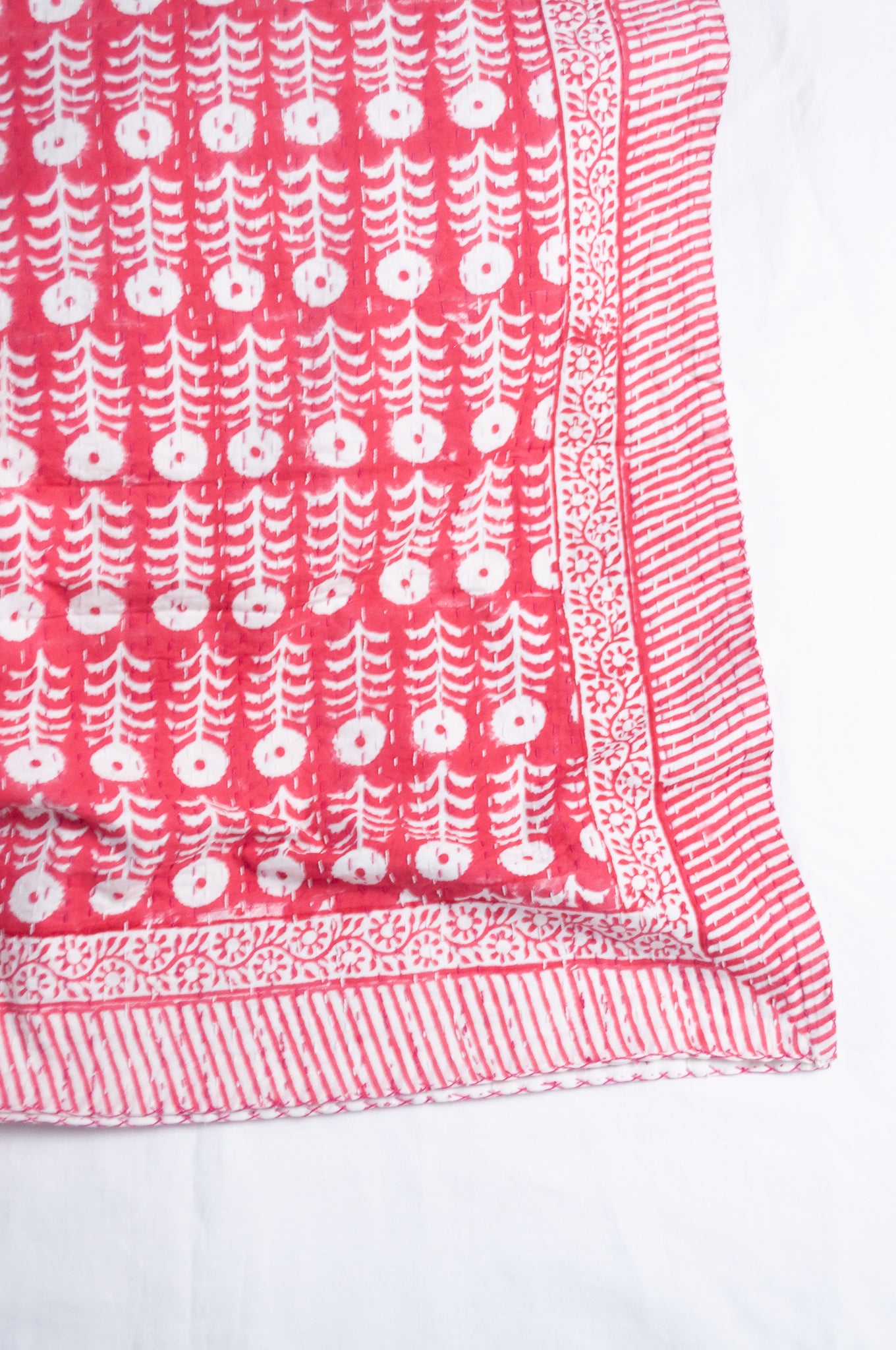 Pink and white floral blockprint cotton kantha quilt.