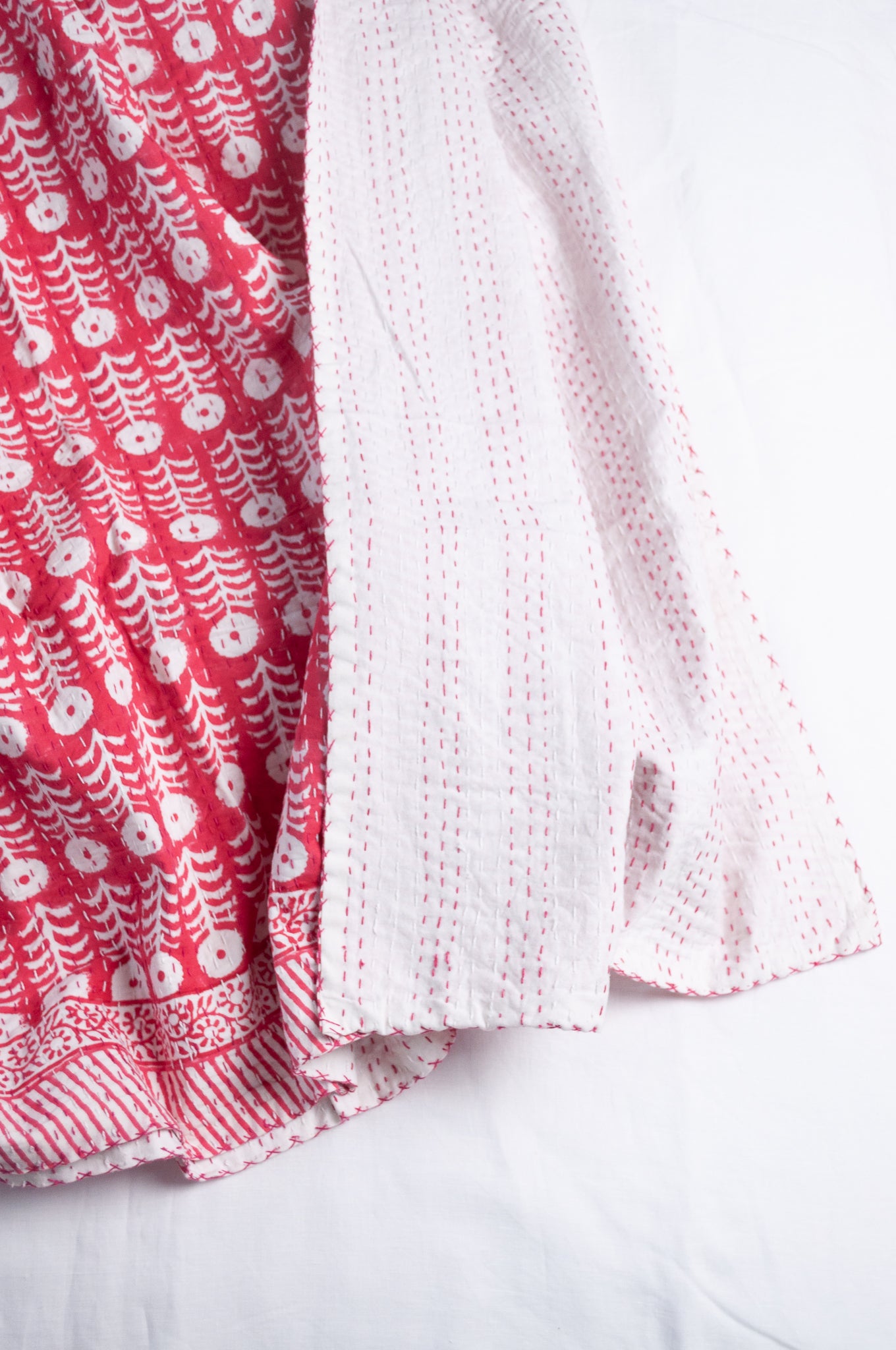 Pink and white floral blockprint cotton kantha quilt.