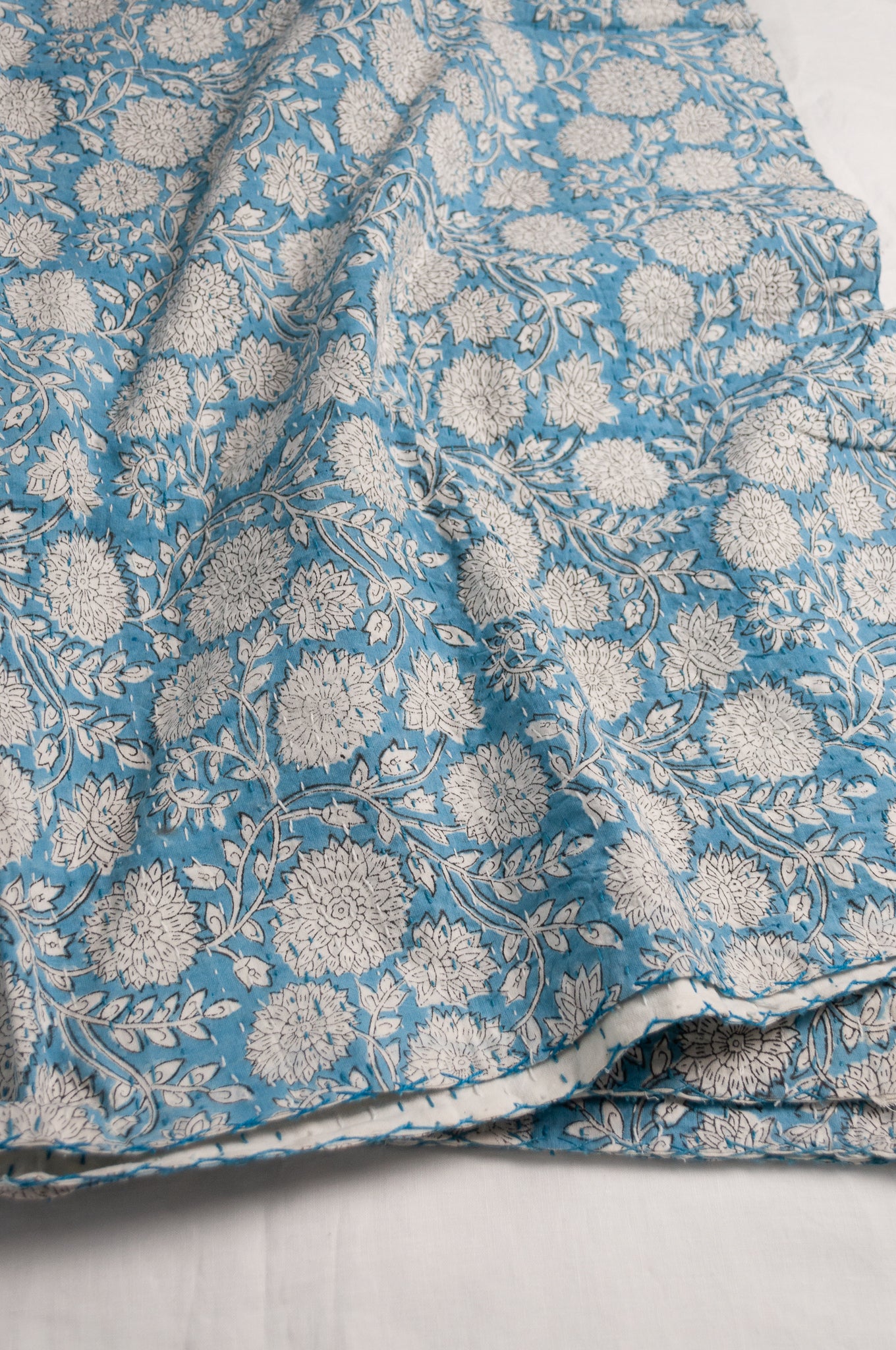Cotton kantha quilt in sky blue and white floral.