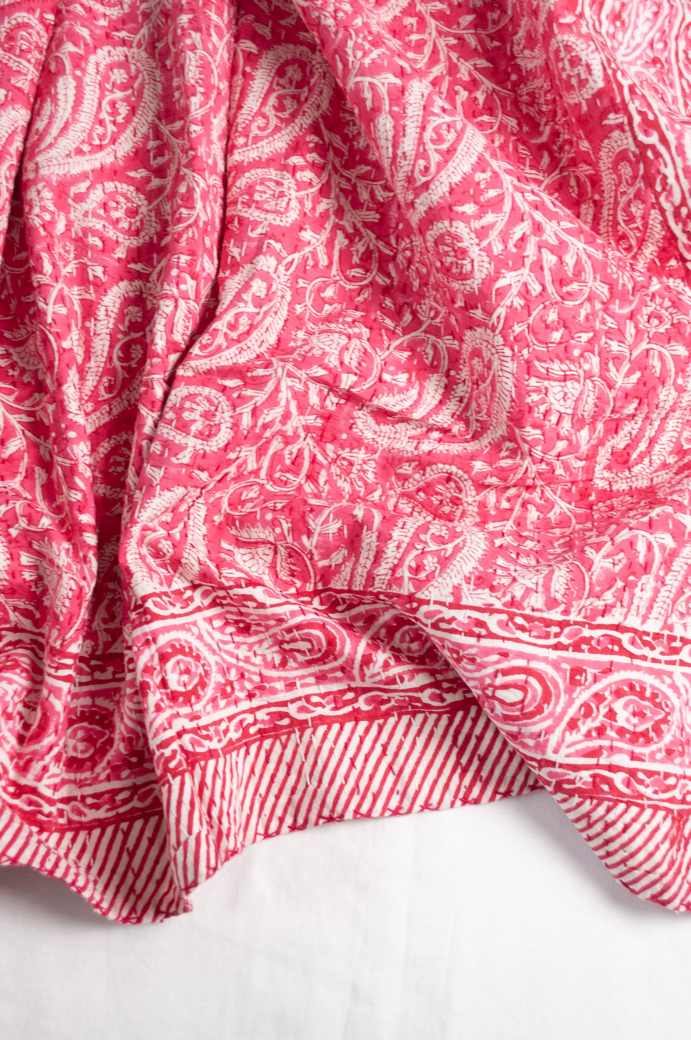 Raspberry pink and white paisley cotton kantha quilt.
