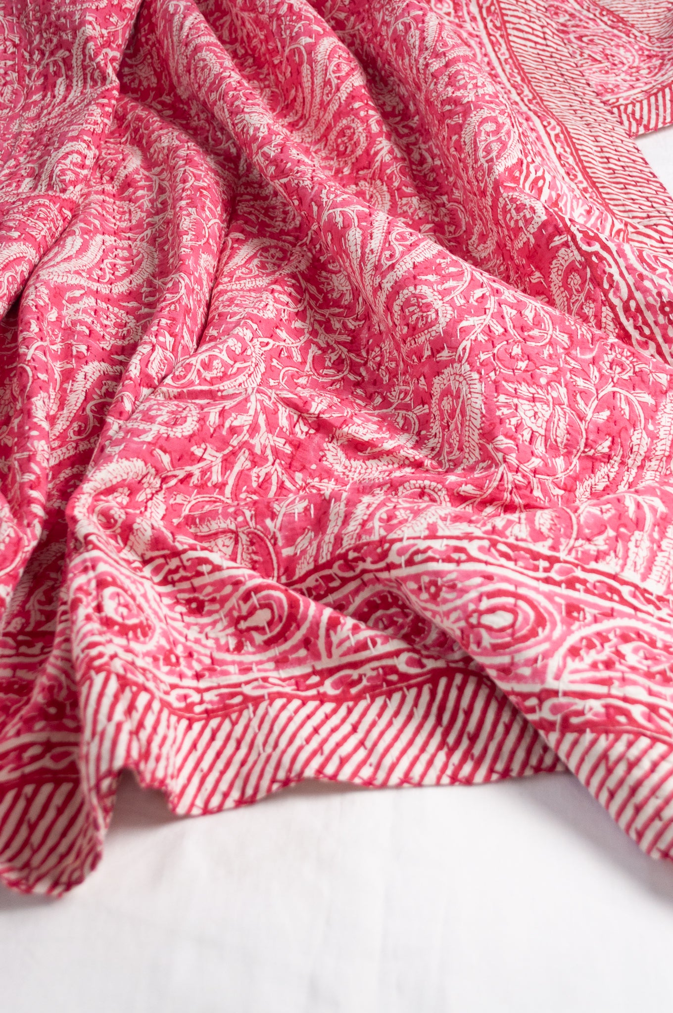Raspberry pink and white paisley cotton kantha quilt.