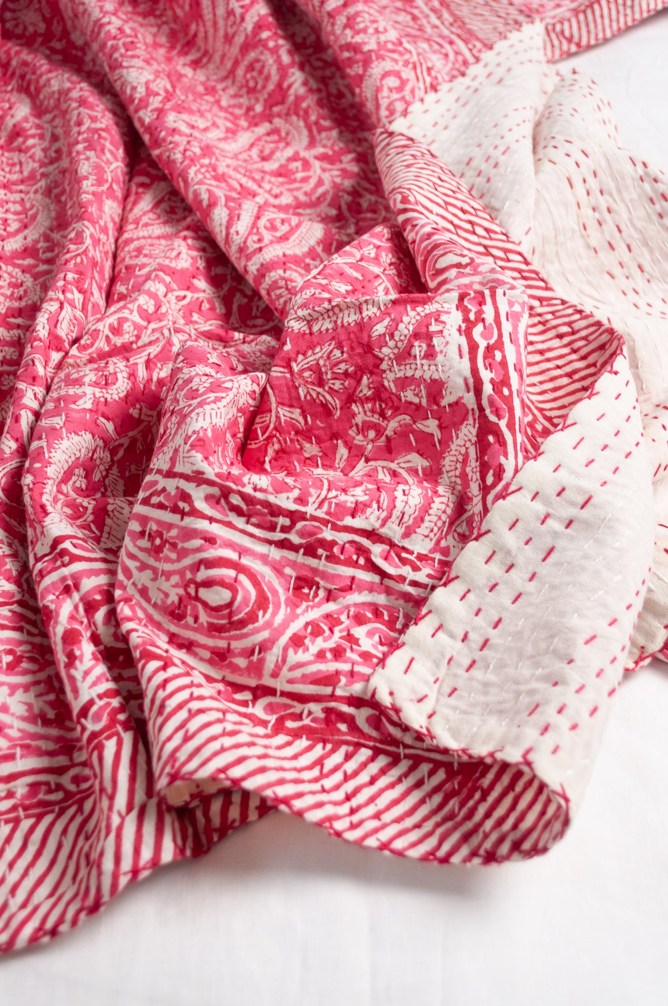 Raspberry pink and white paisley cotton kantha quilt.