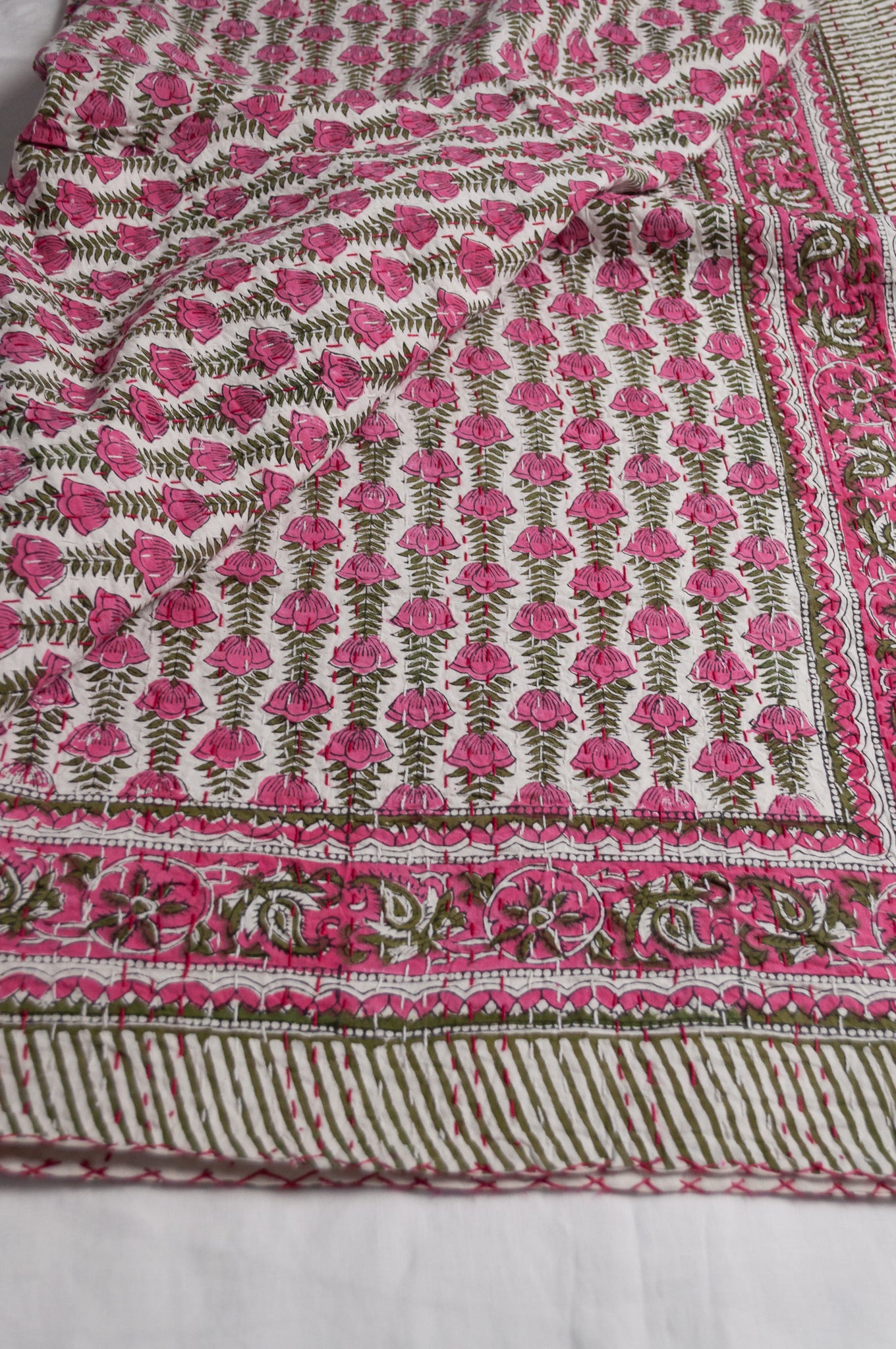 Pink green and white floral cotton kantha quilt.