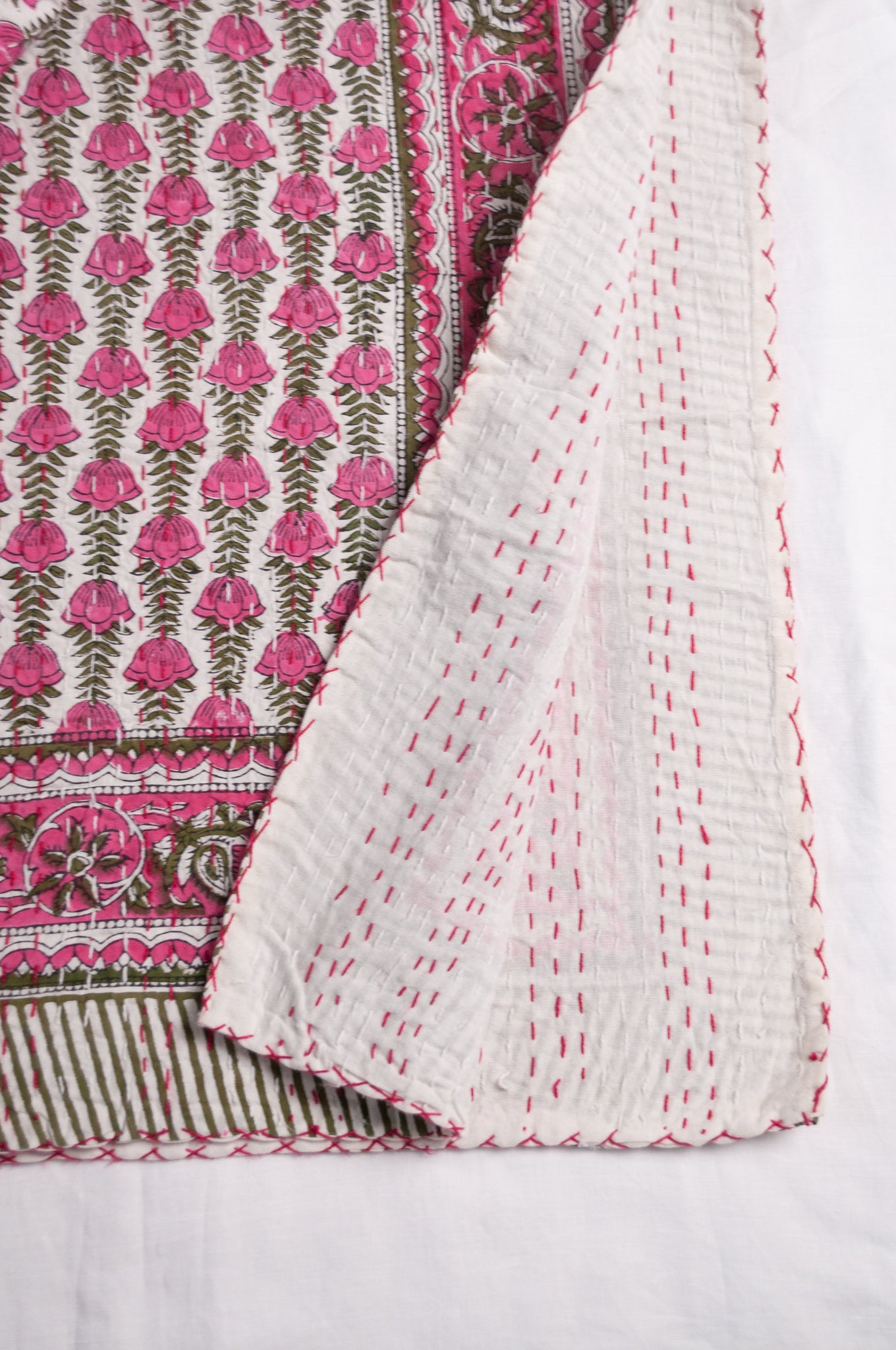 Pink green and white floral cotton kantha quilt.