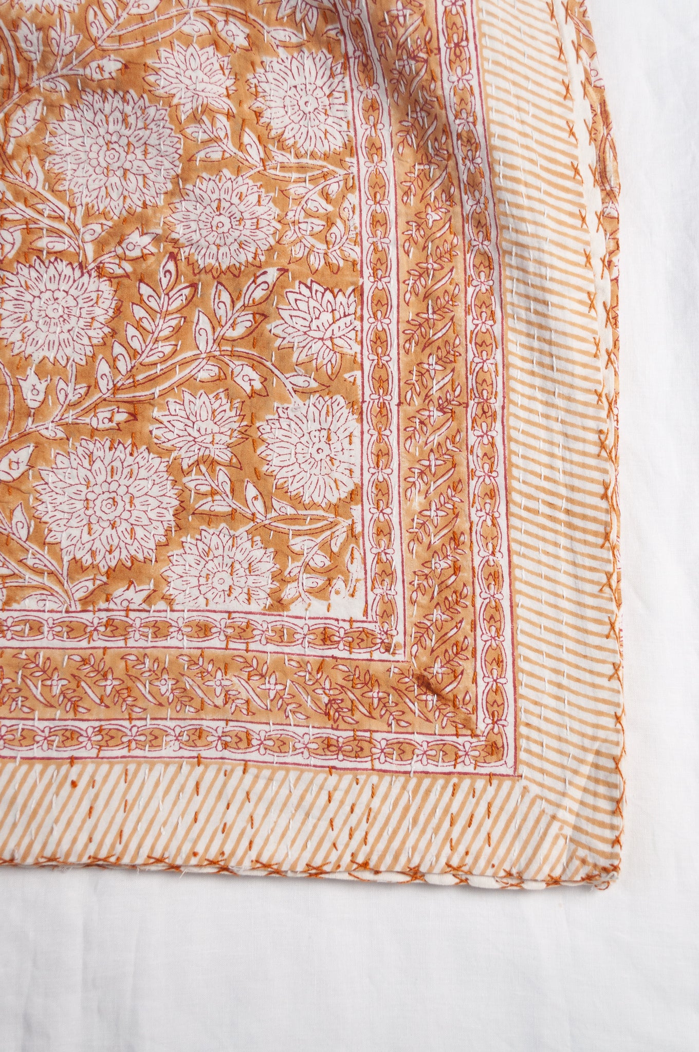 Cotton kantha quilt in mustard yellow and white floral.