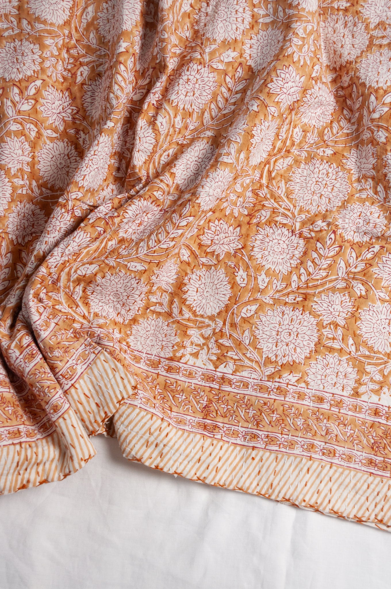Cotton kantha quilt in mustard yellow and white floral.