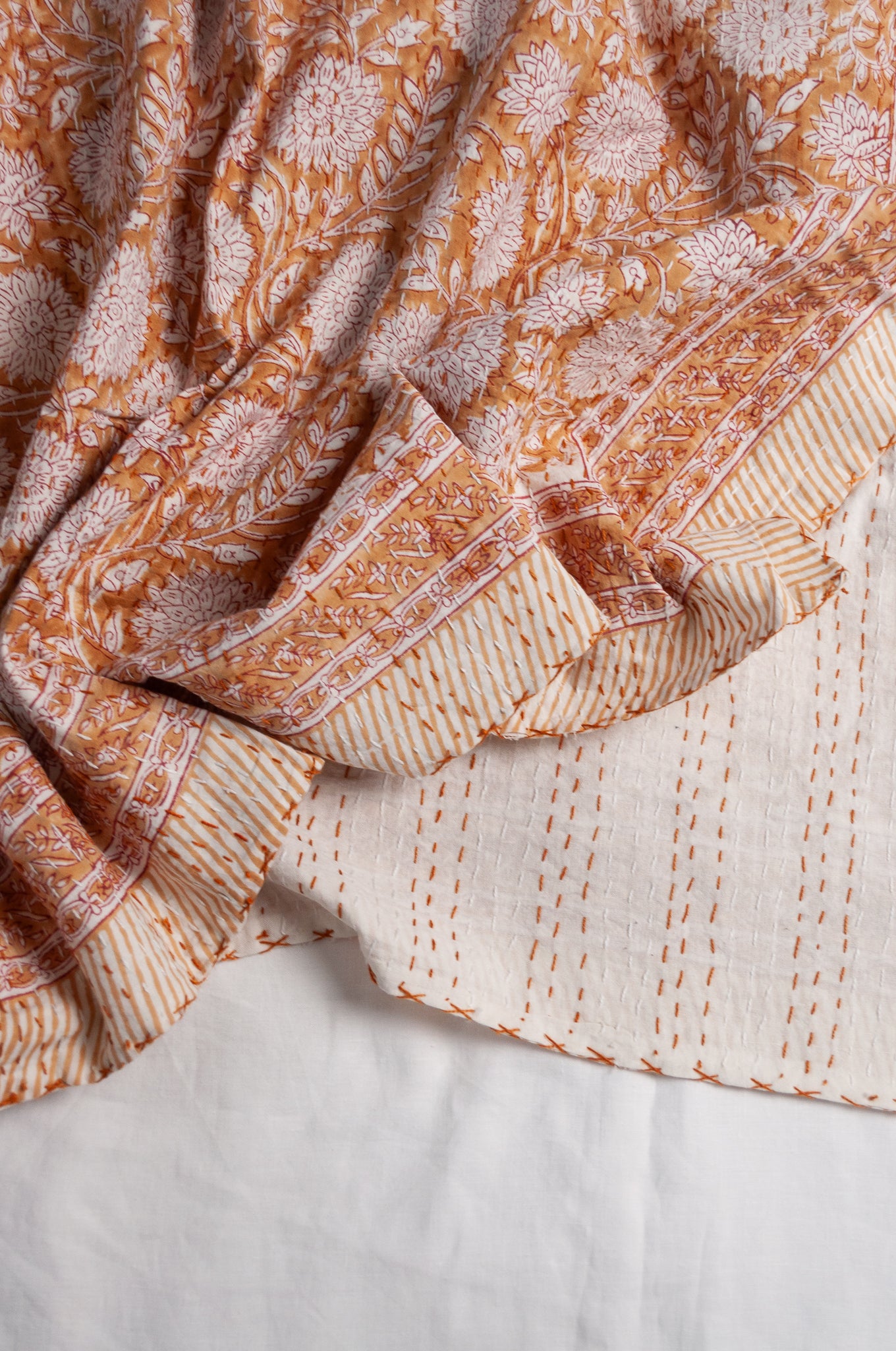 Cotton kantha quilt in mustard yellow and white floral.